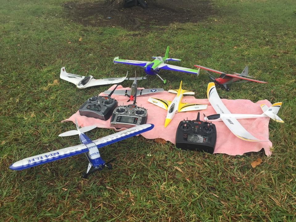 Collection Of Model Airplanes And Remote Controls On A Grassy Lawn — Midtown Hobbies In Lismore, NSW