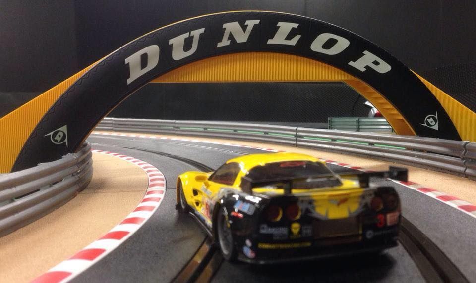 Yellow And Black Race Car On A Slot Car Track, Passing Under A Dunlop Arch — Midtown Hobbies In Lismore, NSW