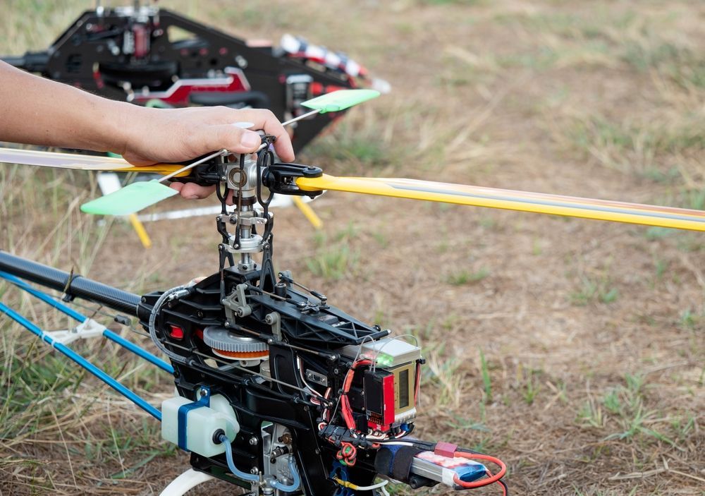 Person Holding The Rotors Of A Model Helicopter Outdoors — Midtown Hobbies In Lismore, NSW
