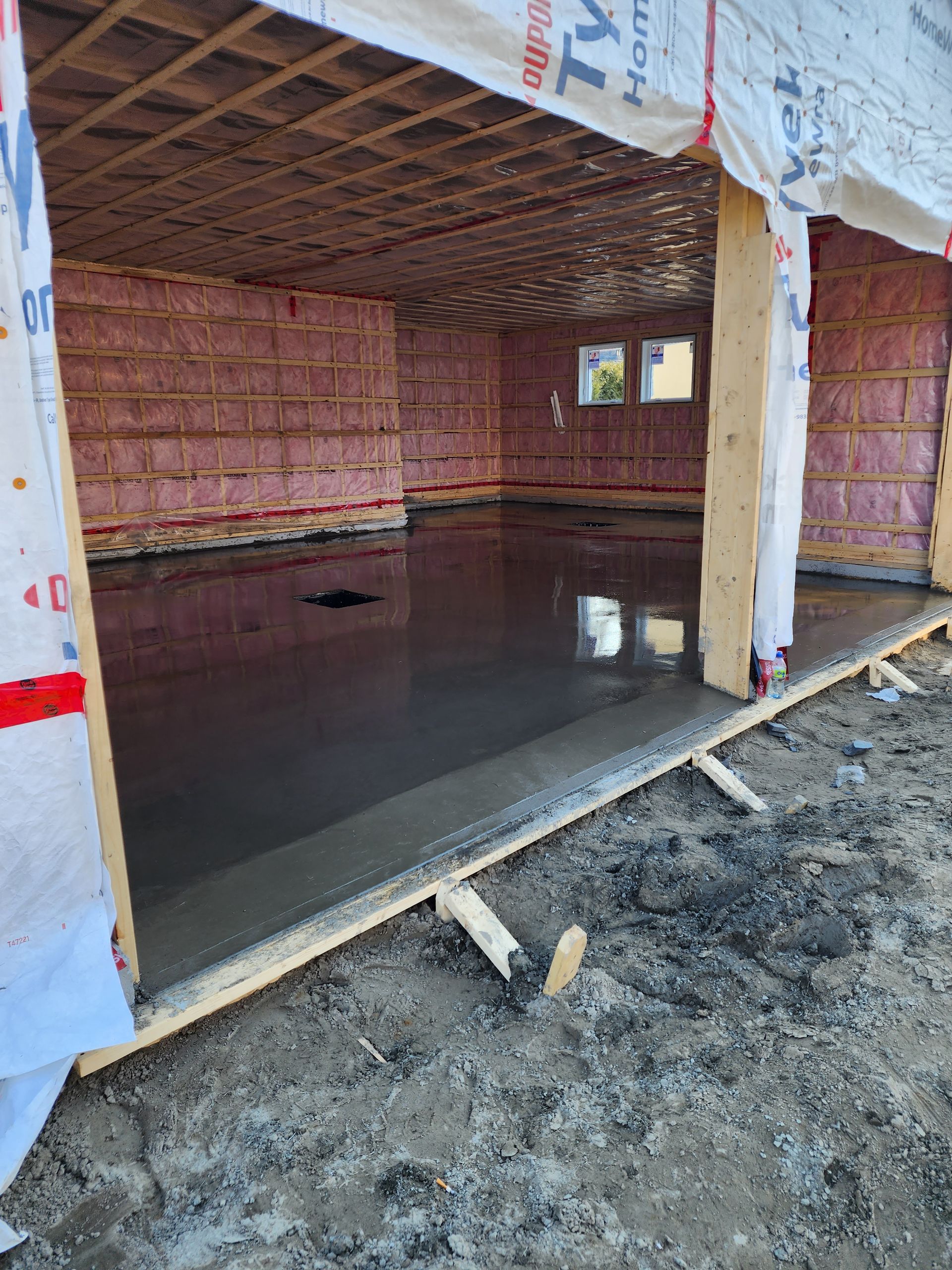 Un sol en béton est en train d'être coulé dans un bâtiment en construction.