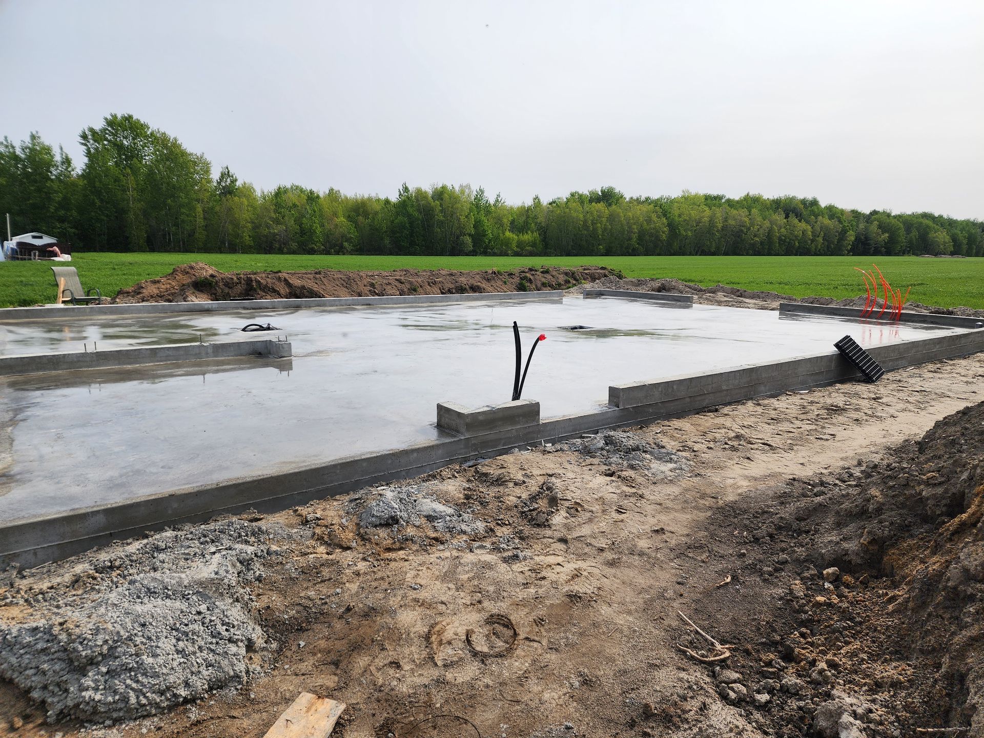 Une fondation en béton est en cours de construction dans un champ