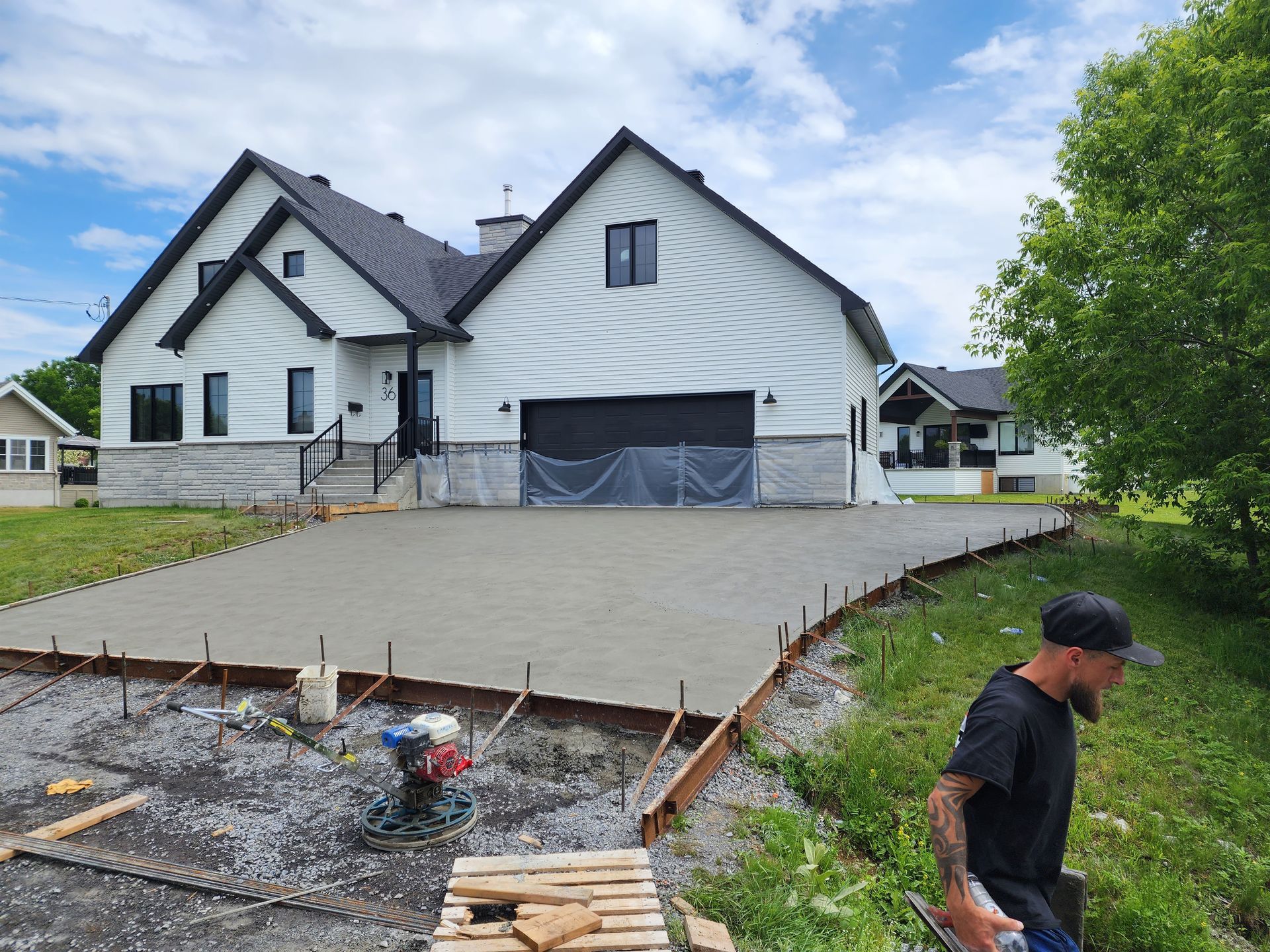Un homme se tient devant une grande maison blanche.