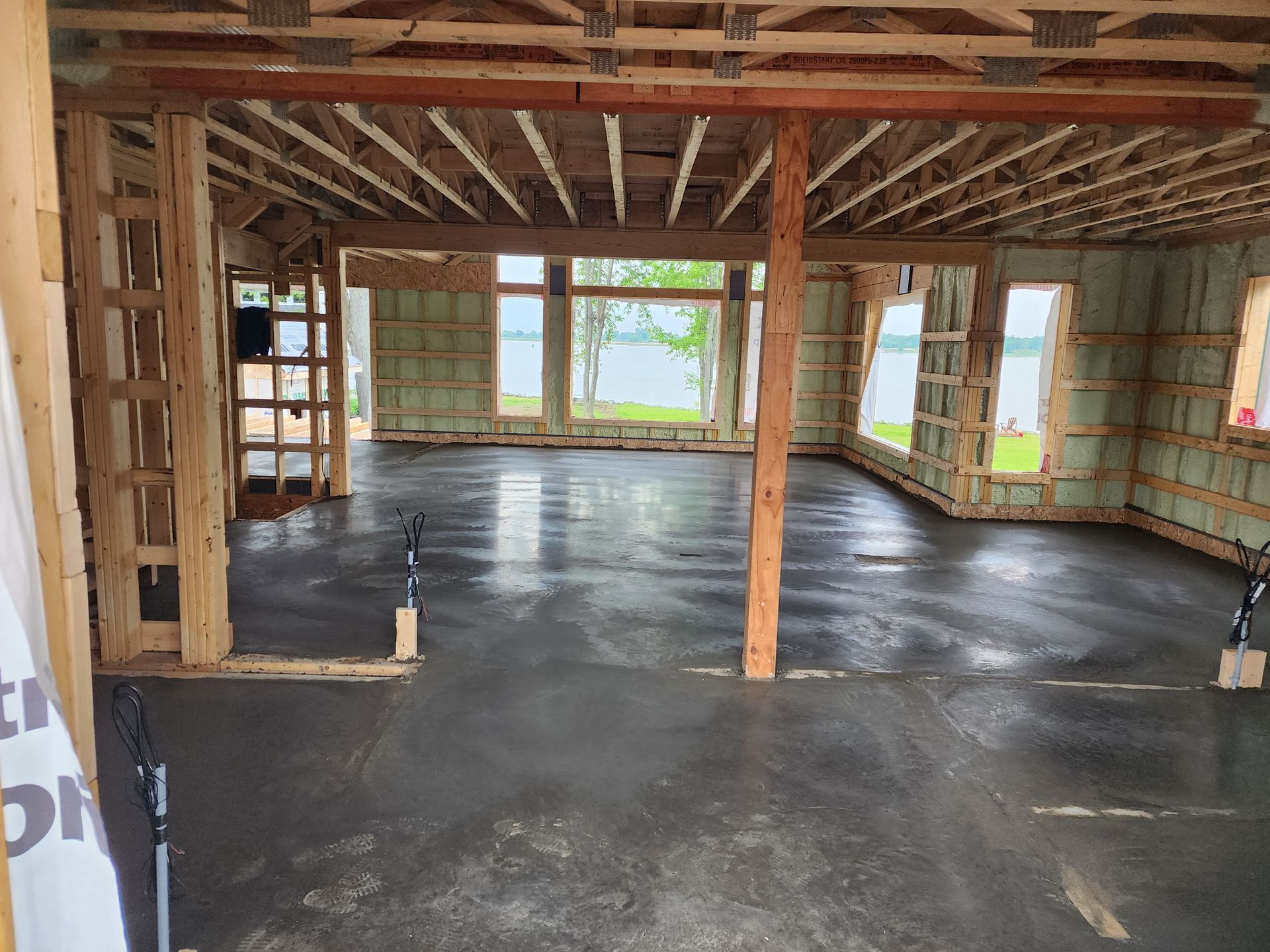 Une grande pièce avec beaucoup de fenêtres et un sol en béton.