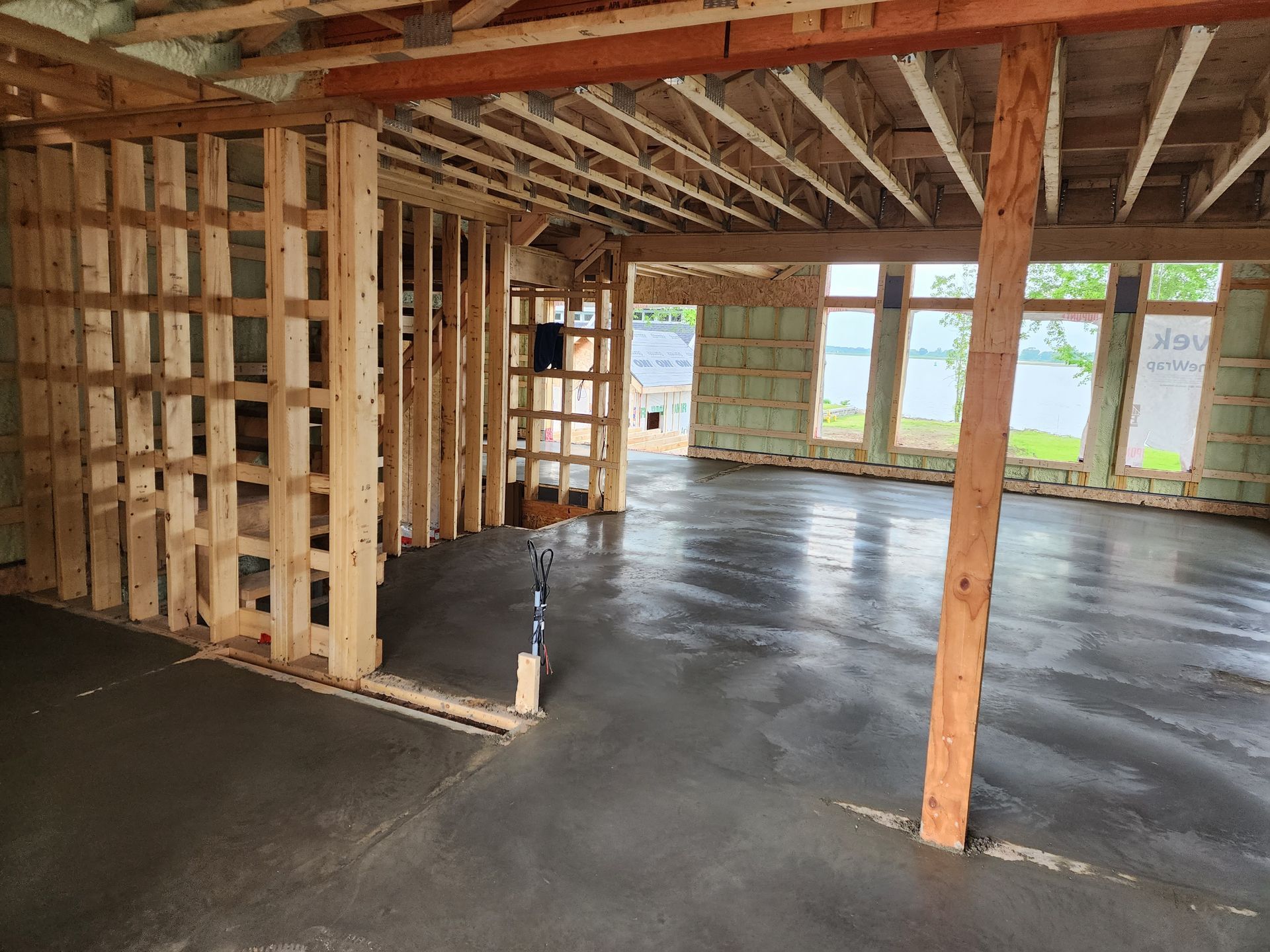 Une pièce avec un sol en béton et des murs en bois en construction.