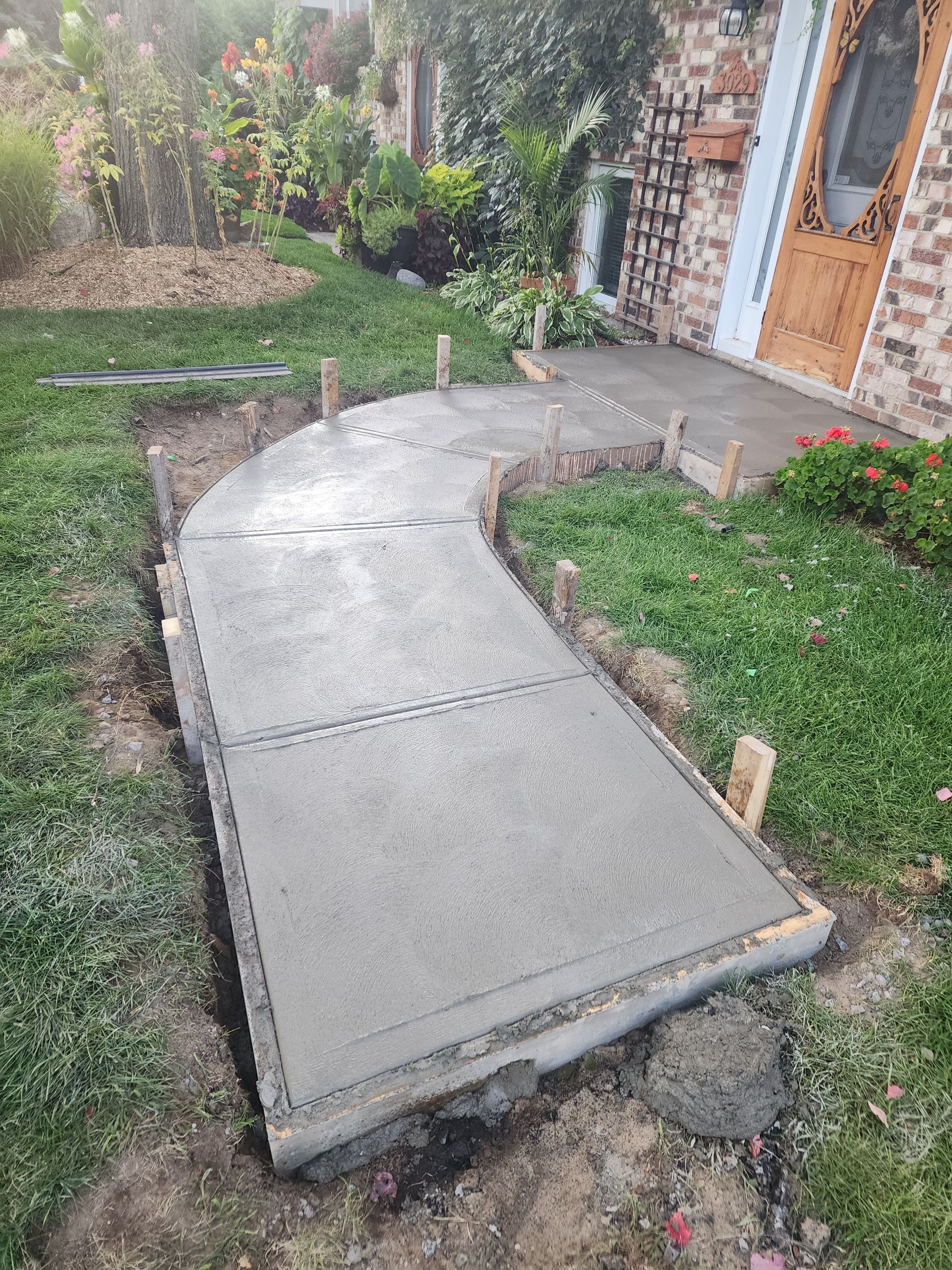 Une passerelle en béton est en cours de construction devant une maison.