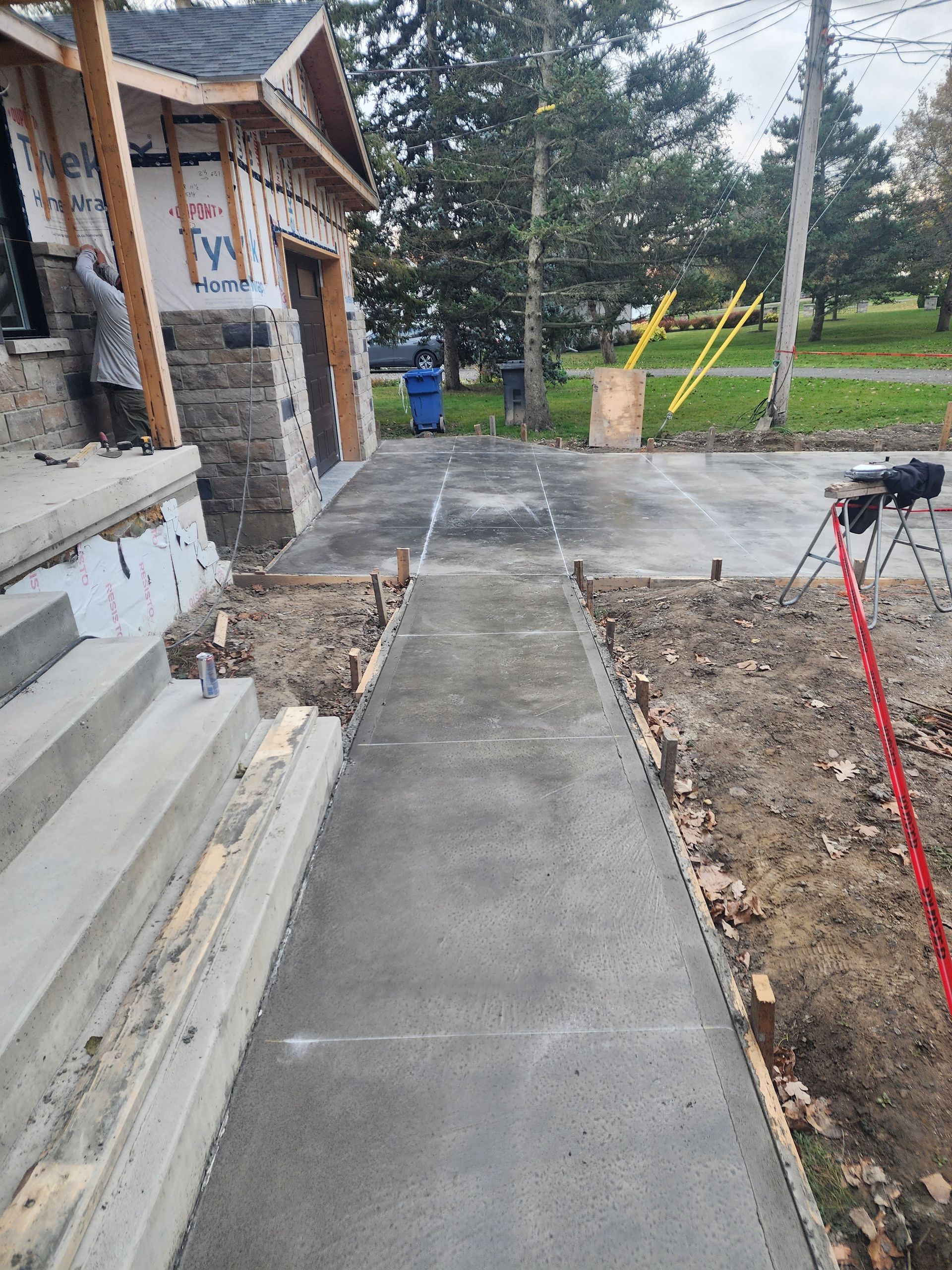 Une passerelle en béton est en cours de construction devant une maison en construction.