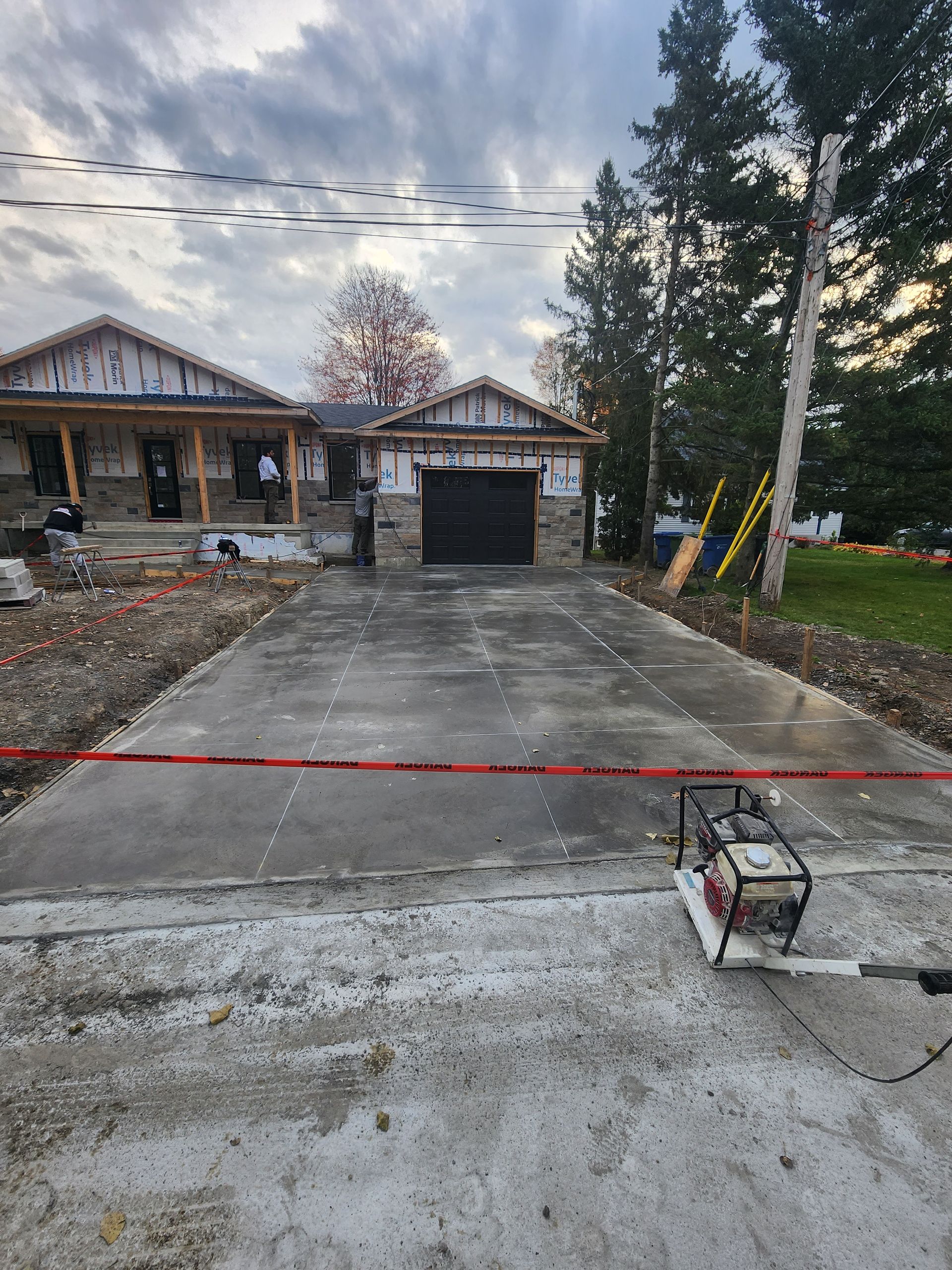 Une allée en béton est en cours de construction devant une maison.