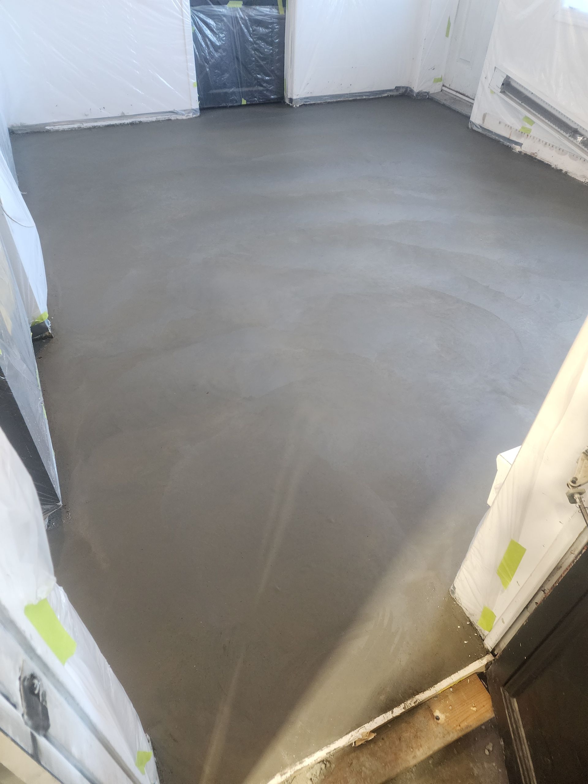 Une pièce avec un sol en béton et une porte.