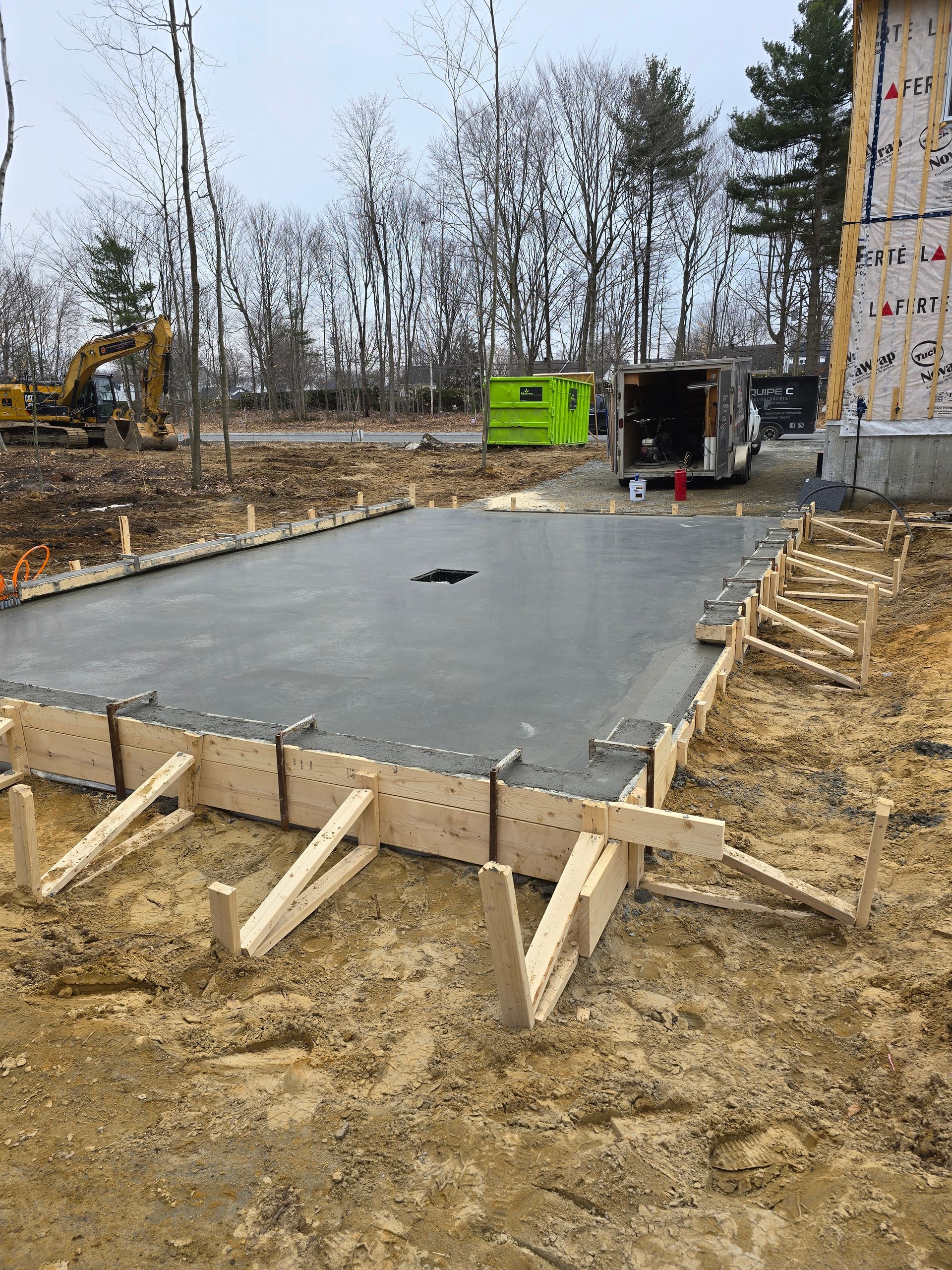Une dalle de béton est en train d'être coulée sur un chantier de construction.