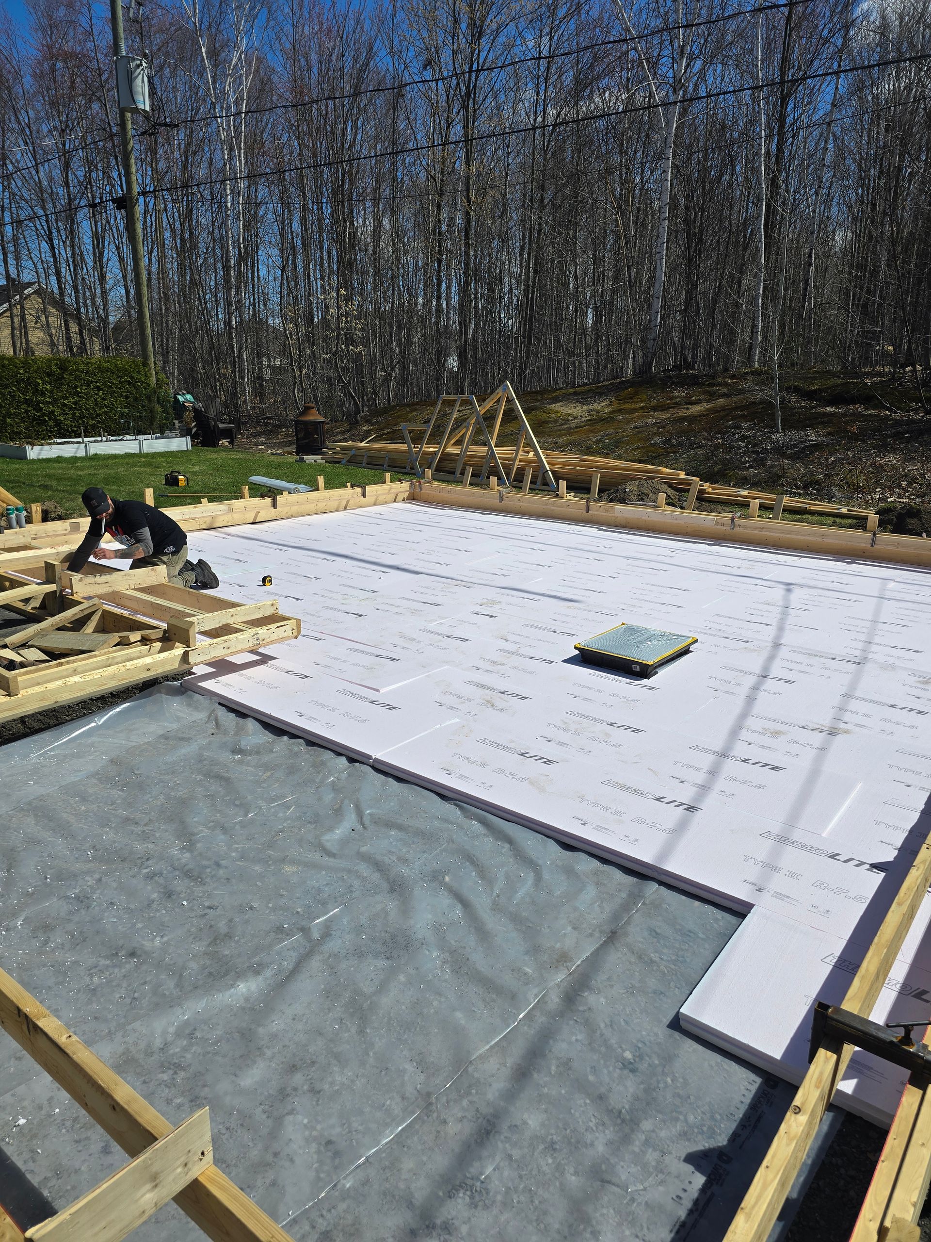Un homme travaille sur les fondations d'une maison.