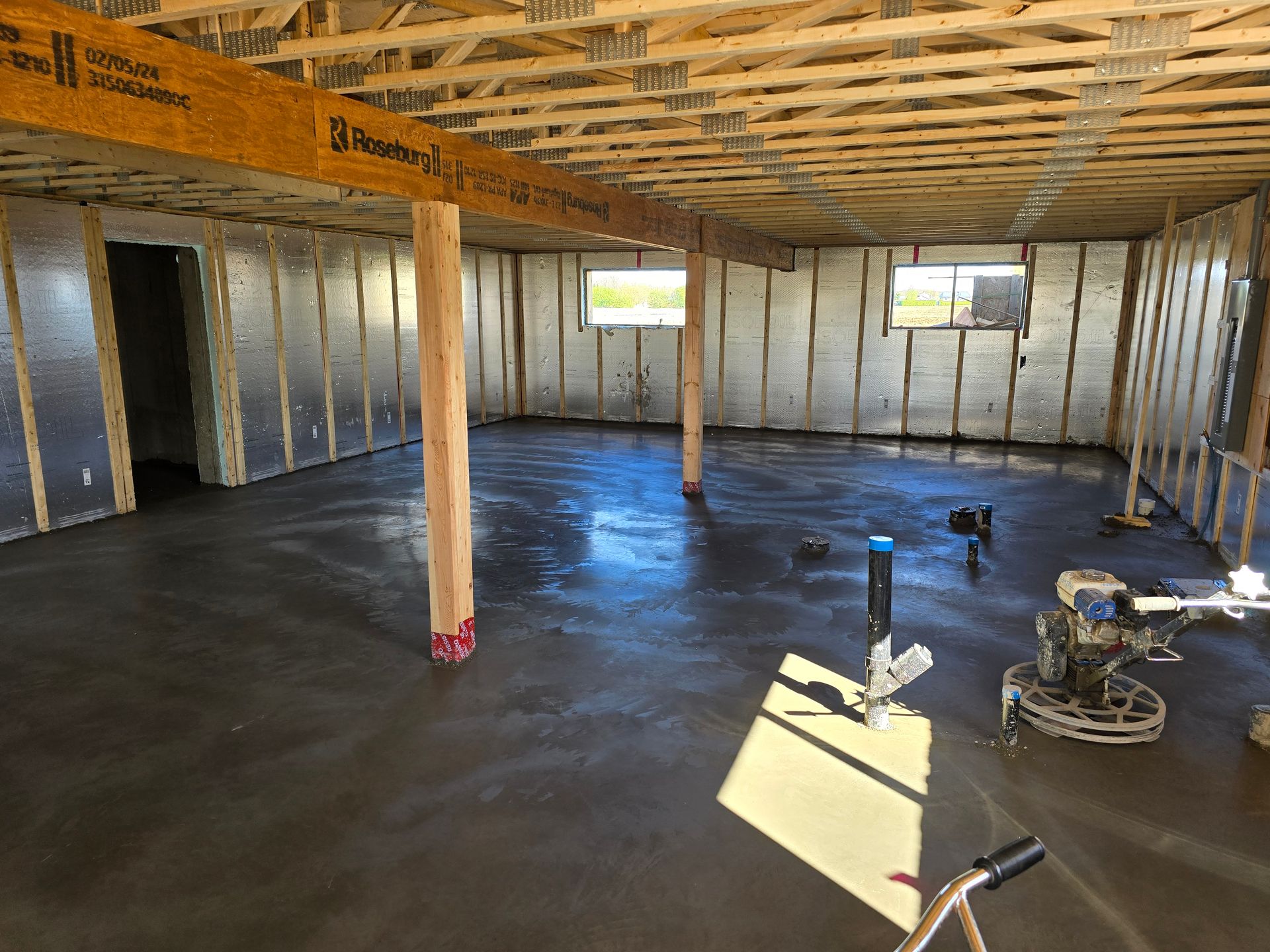 Un plancher en béton est en train d'être coulé dans un sous-sol en construction.