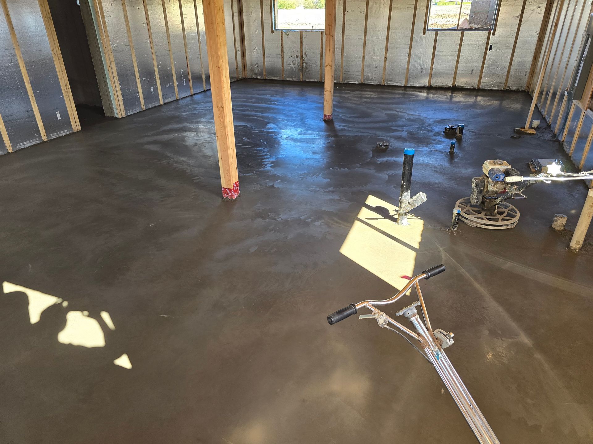 Un sol en béton est en train d'être coulé dans un sous-sol.