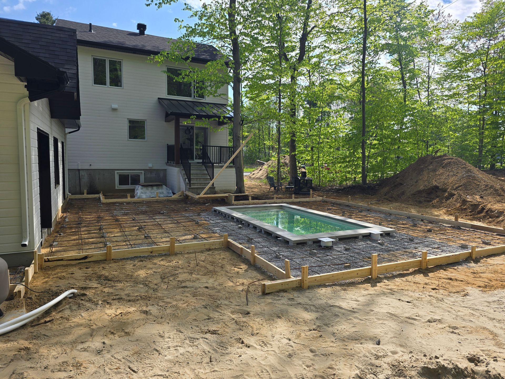 Une piscine est en cours de construction dans l'arrière-cour d'une maison.