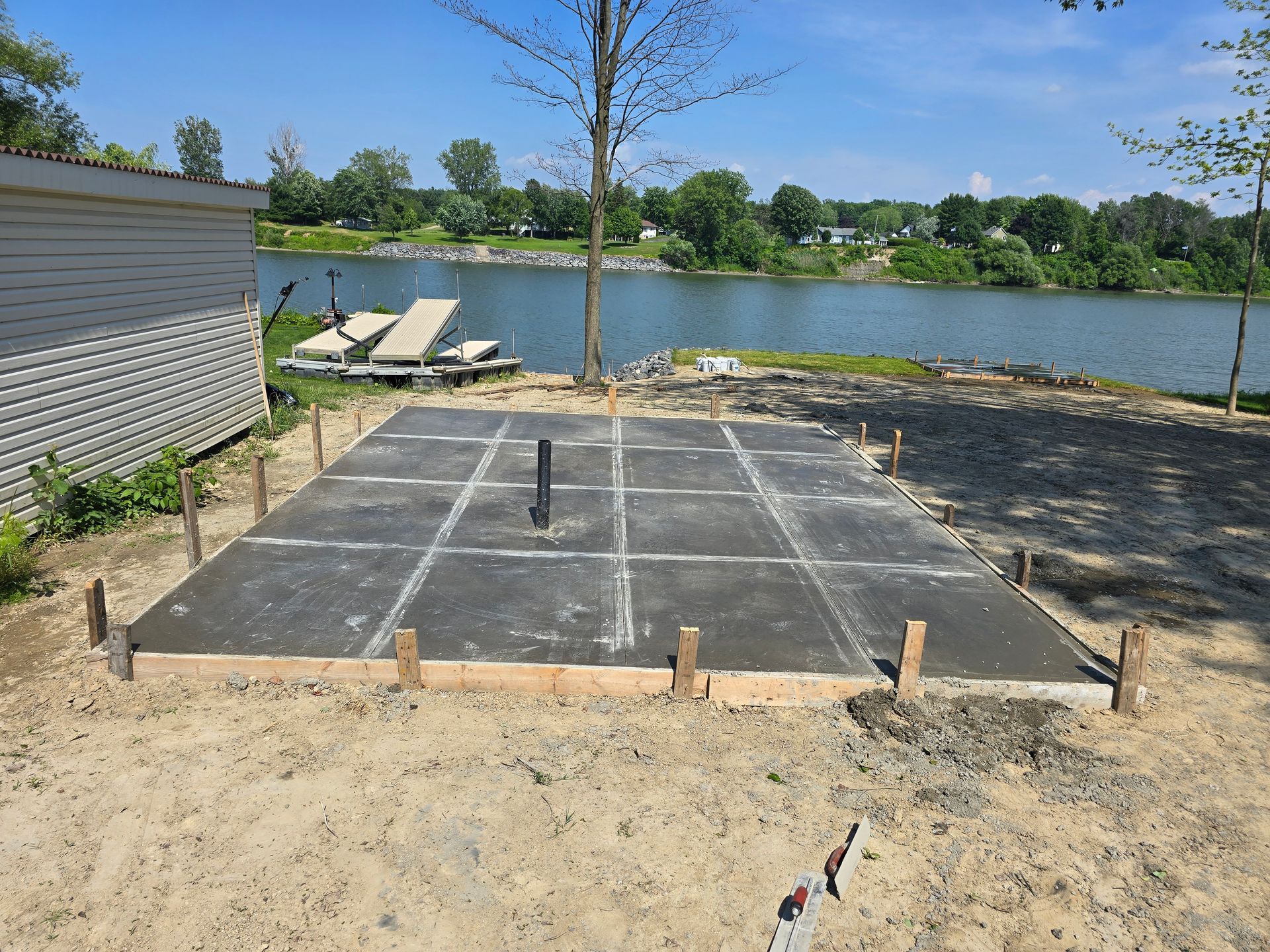 Une fondation en béton est en cours de construction à côté d'un lac