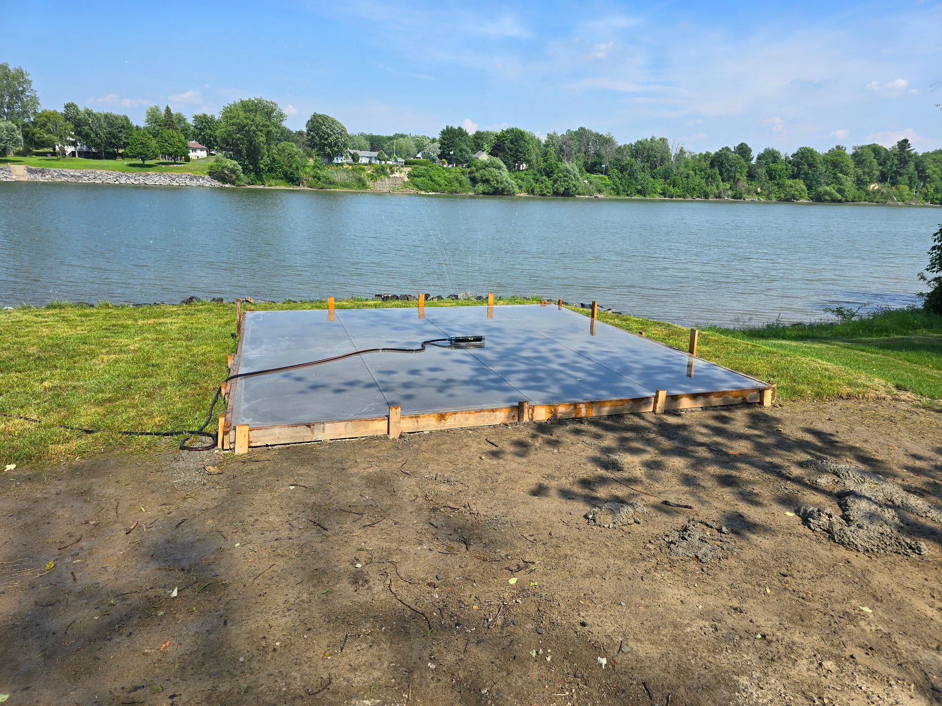 Une dalle de béton est en cours de construction sur la rive d'un lac.