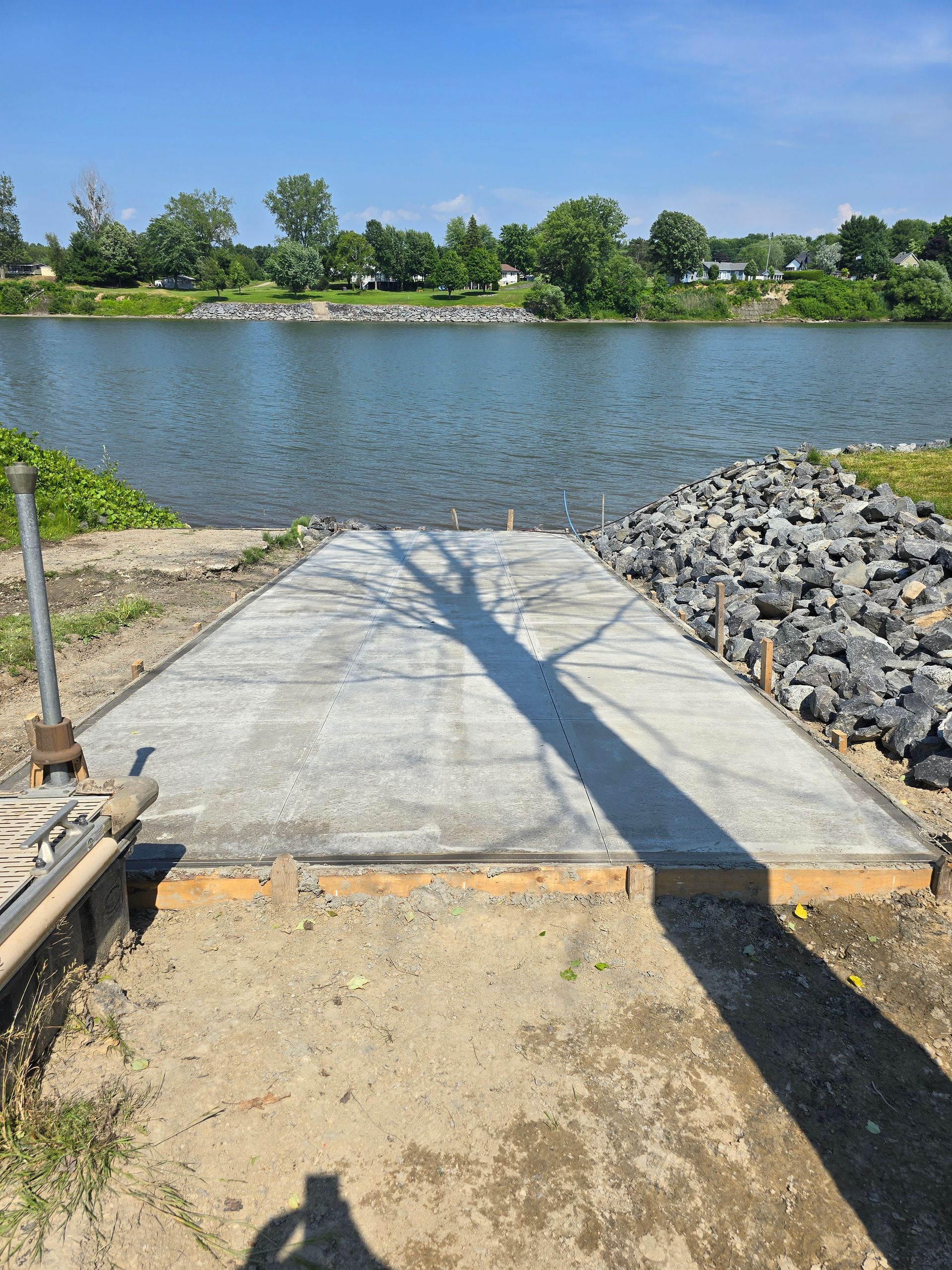 Un quai en béton est en cours de construction à côté d'un plan d'eau.