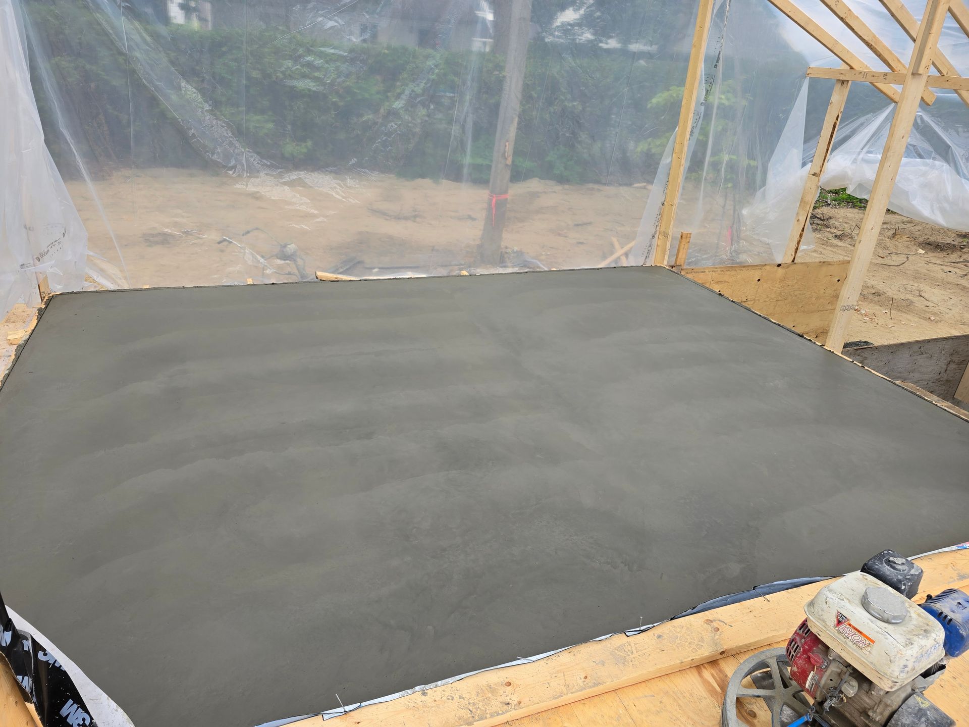 Un sol en béton est en train d'être nivelé avec une machine.