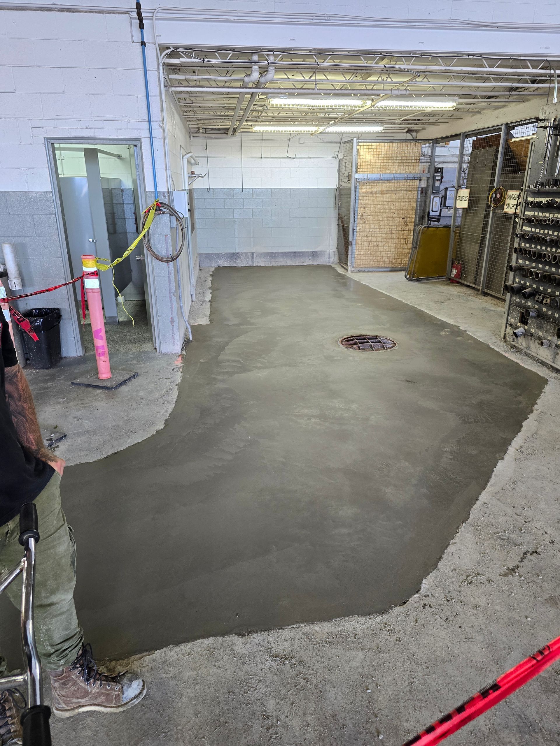 Une personne travaille sur un sol en béton dans un garage.