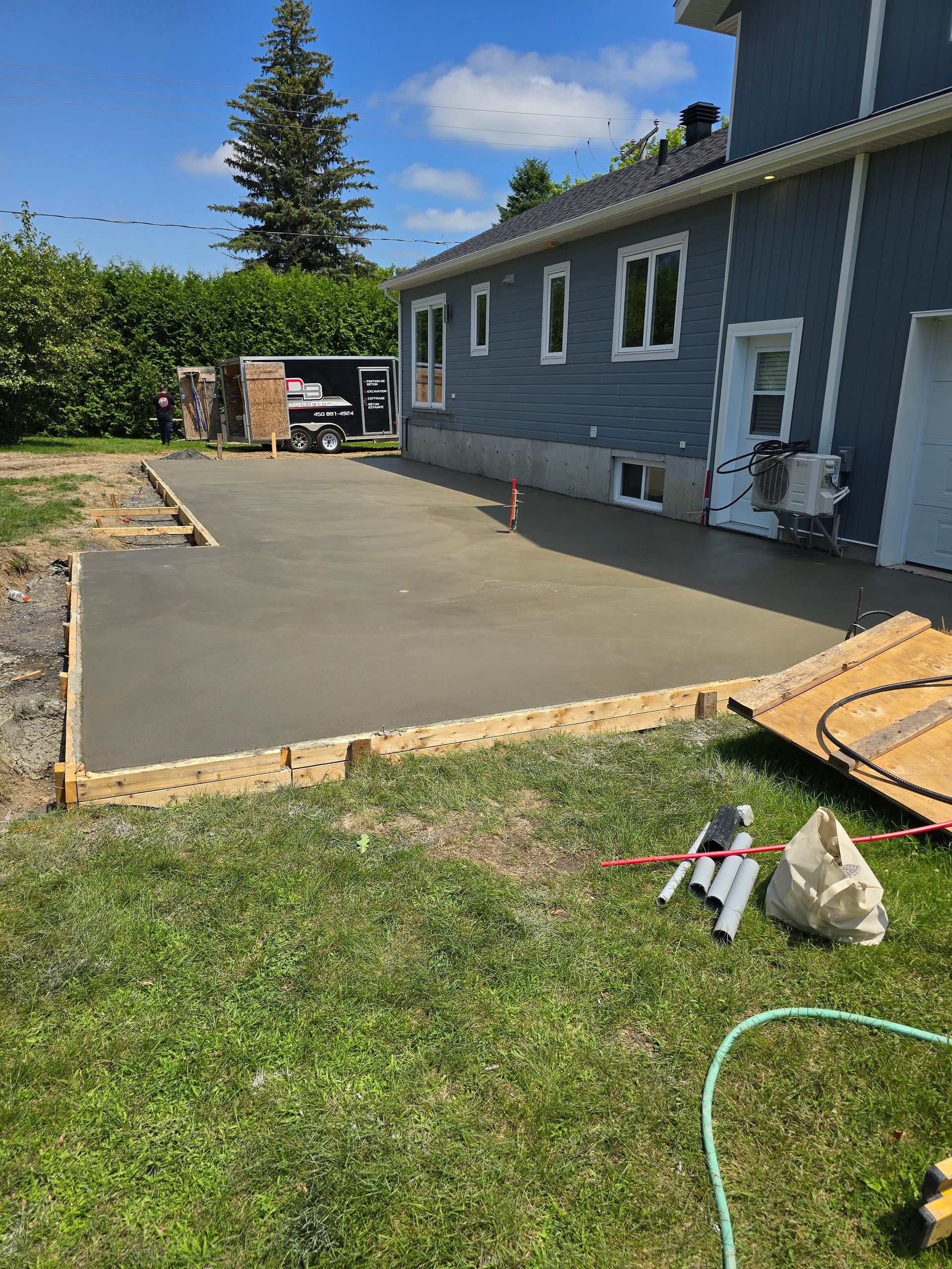 Une allée en béton est en cours de construction devant une maison.