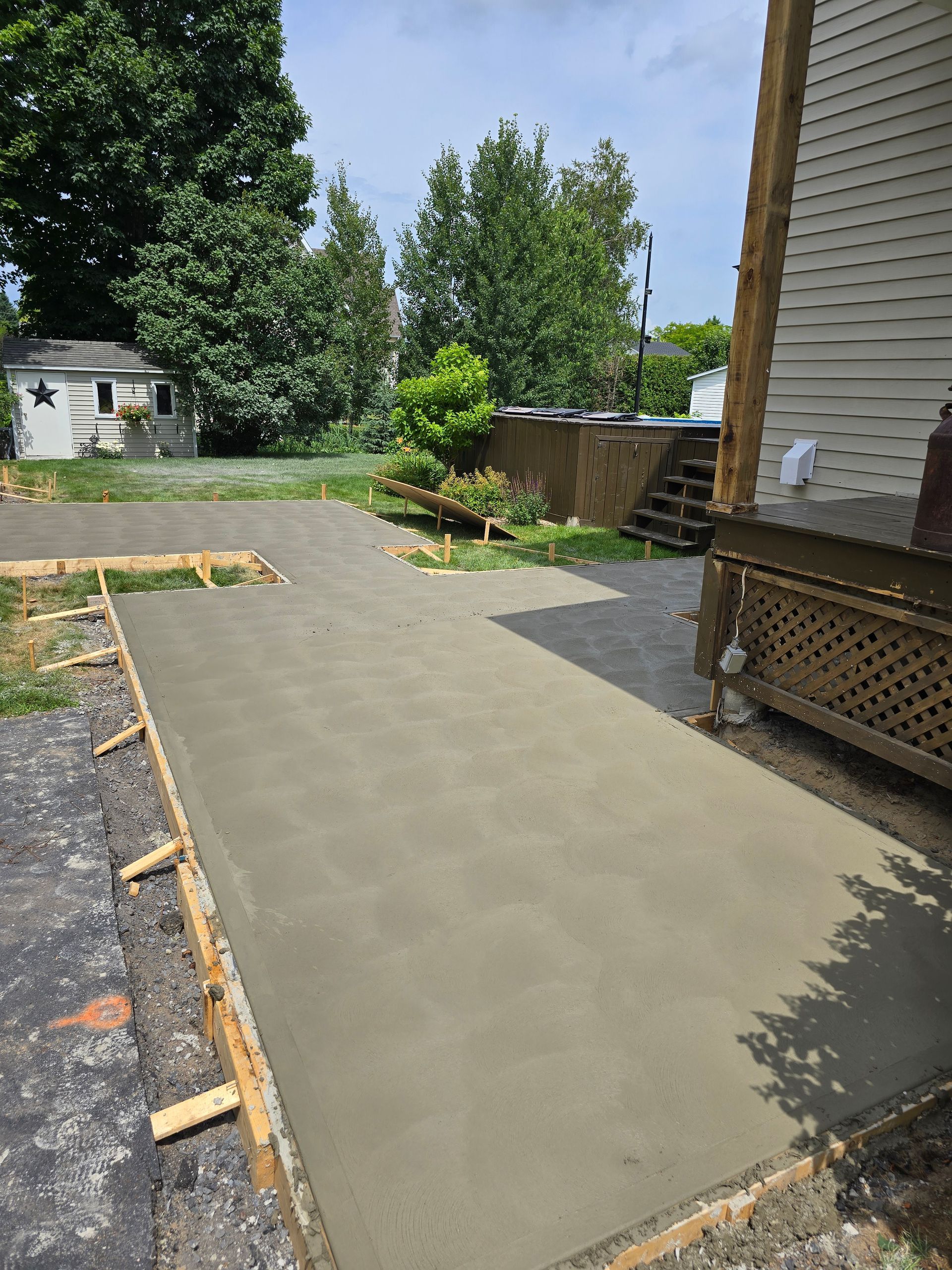 Une passerelle en béton est en cours de construction devant une maison.