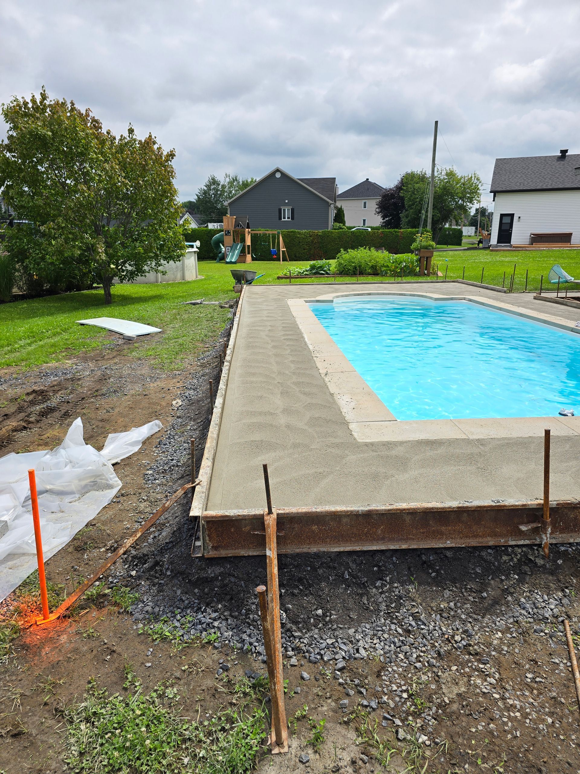 Une piscine est en cours de construction dans l'arrière-cour d'une maison.