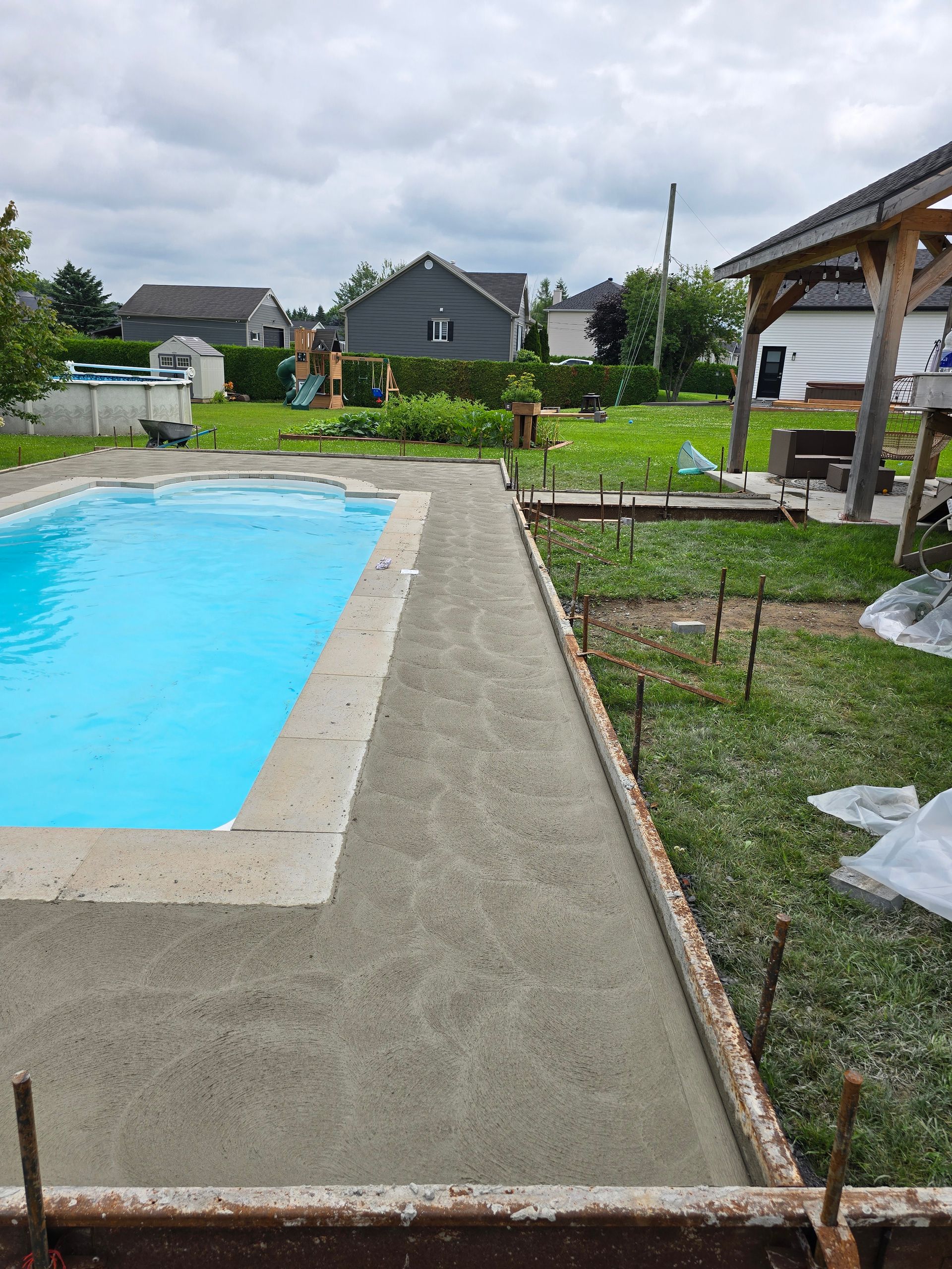 Une piscine est en cours de construction dans une cour arrière.