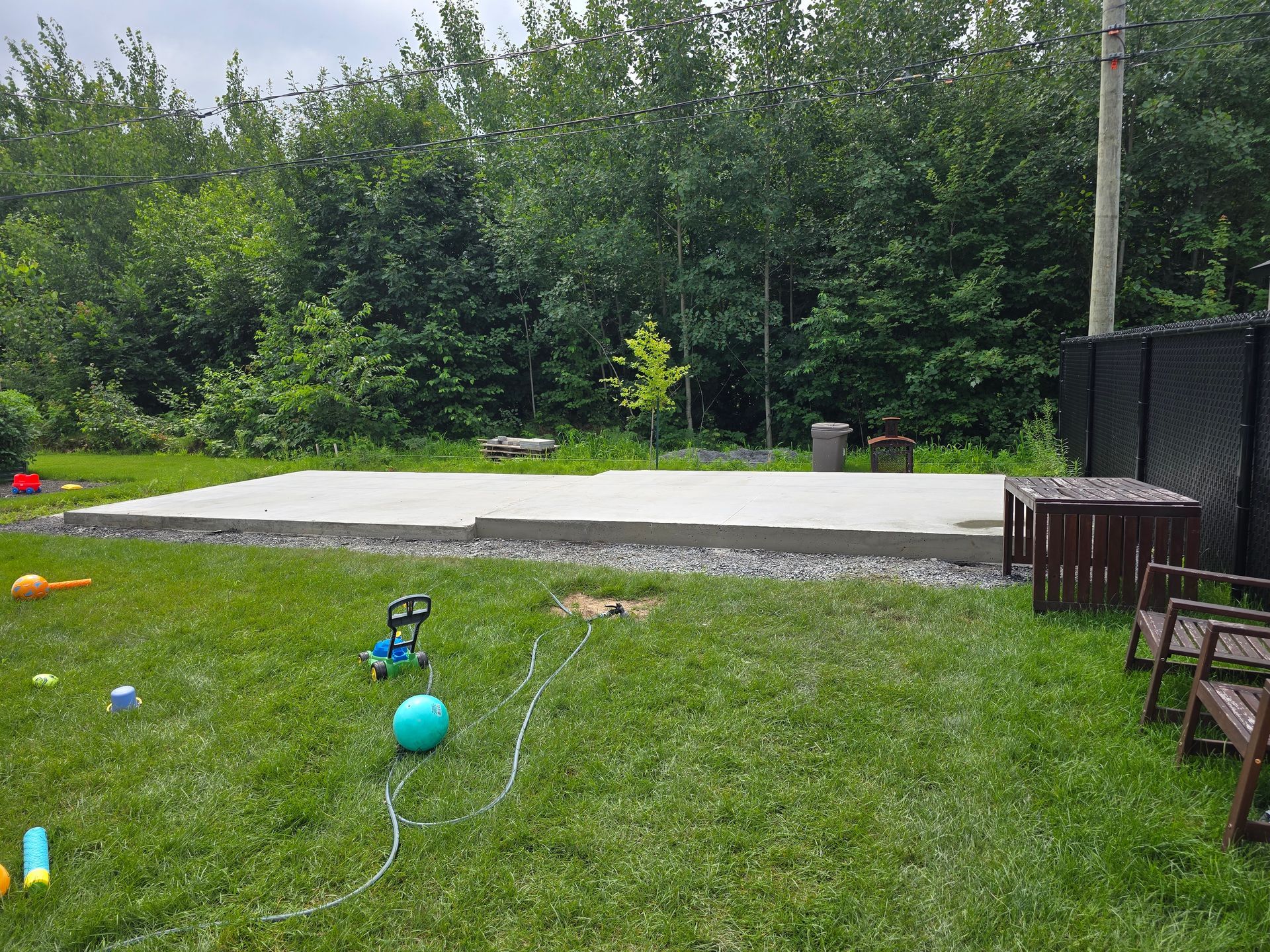 Une pelouse avec une dalle de béton au milieu.