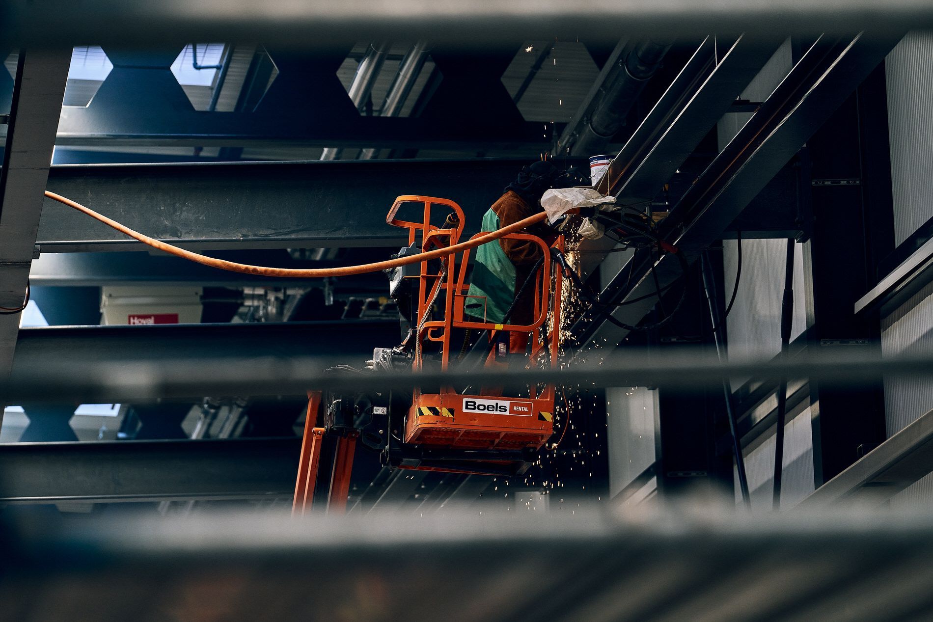 Ein Mann arbeitet an einer Metallkonstruktion auf einem Aufzug.