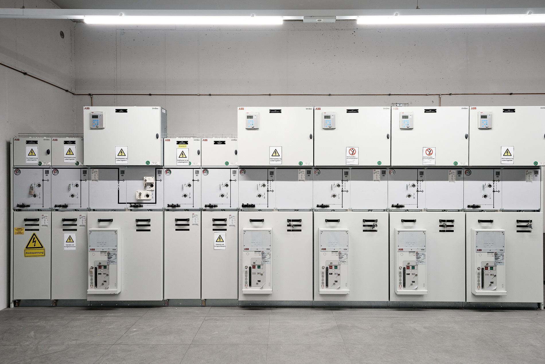 Eine Reihe weißer Schränke mit einem gelben Warnschild darauf