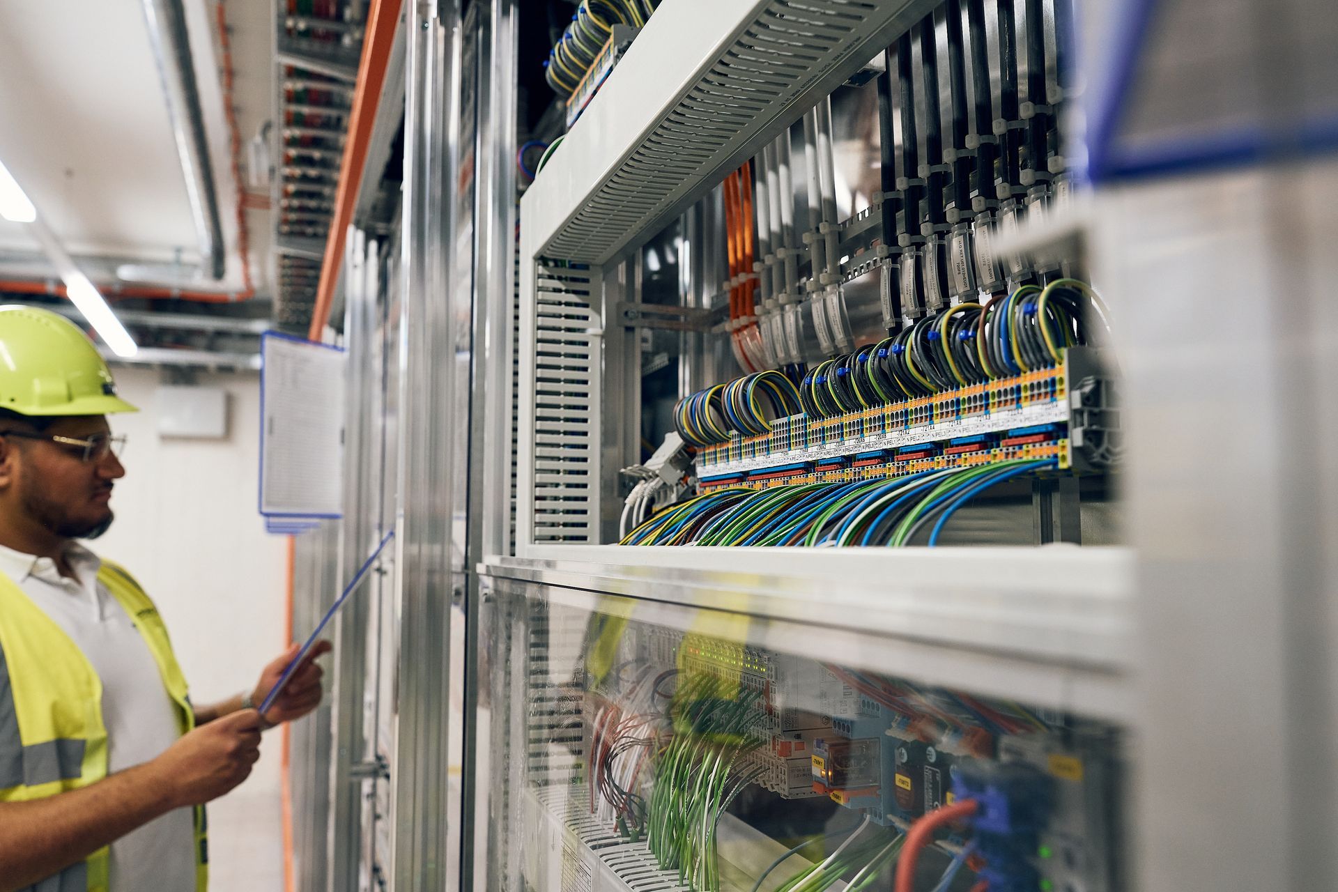 Ein Mann im Rundhalsshirt arbeitet an einem Schaltkasten