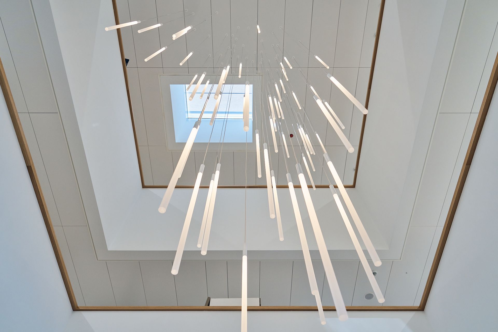 Blick nach oben zur Decke eines Gebäudes, von dem Lichter hängen