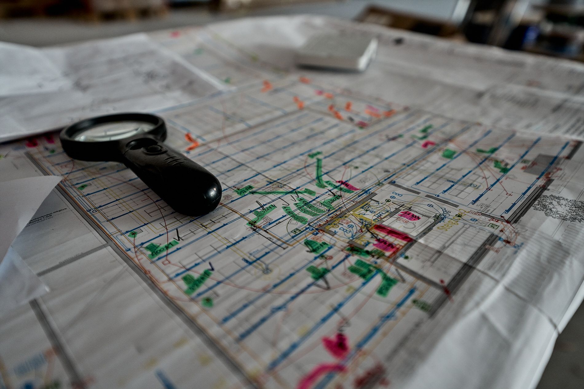 Auf einem Tisch liegt eine Lupe auf einer Karte.