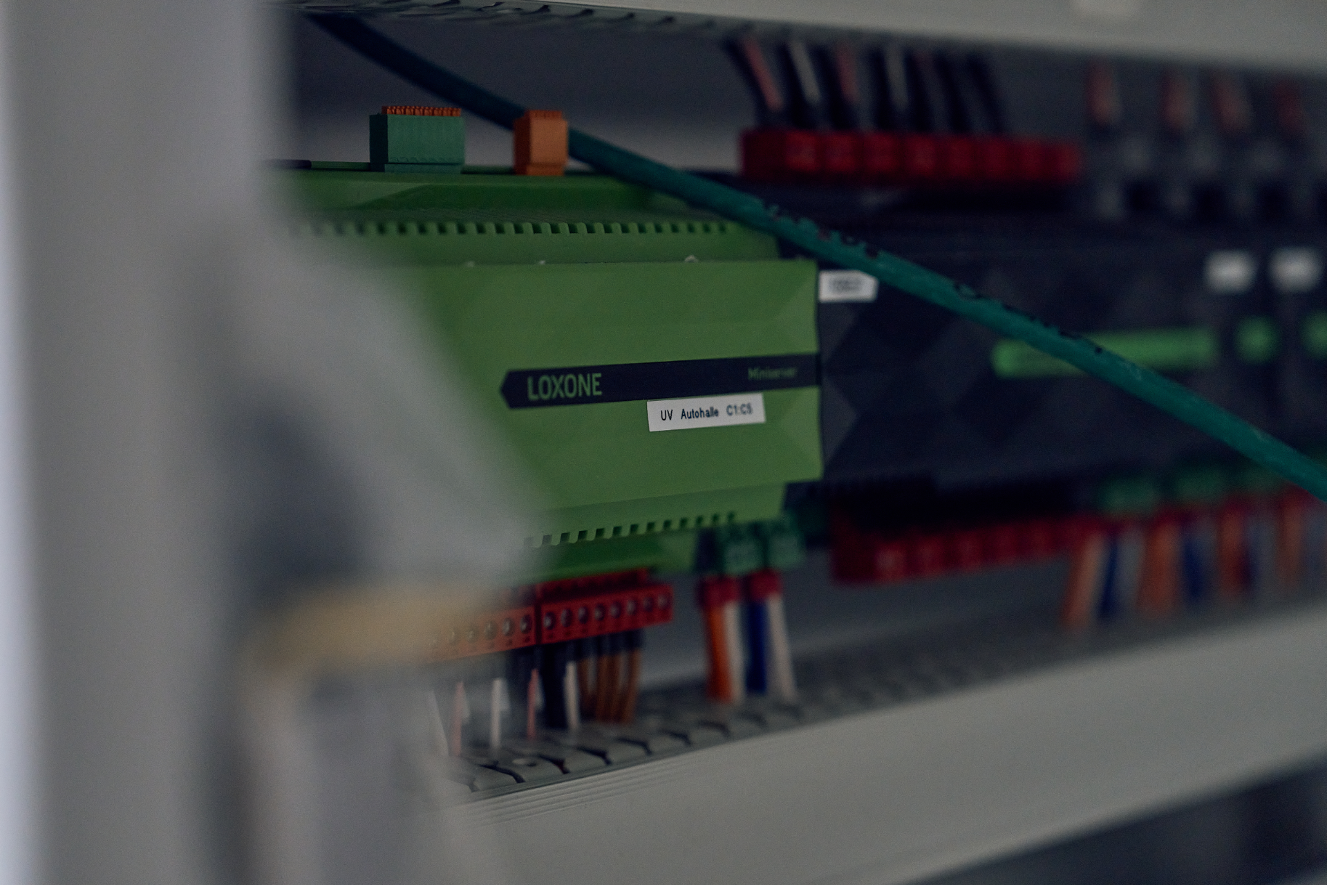 Eine Nahaufnahme eines grünen Schaltkastens, aus dem viele Kabel herauskommen.