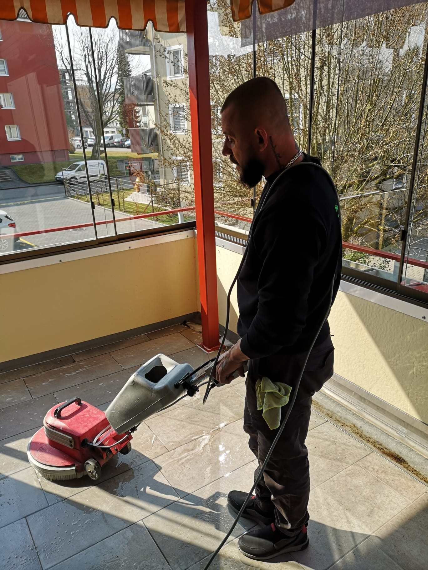 Mann beim maschinellen Reinigen eines Boden