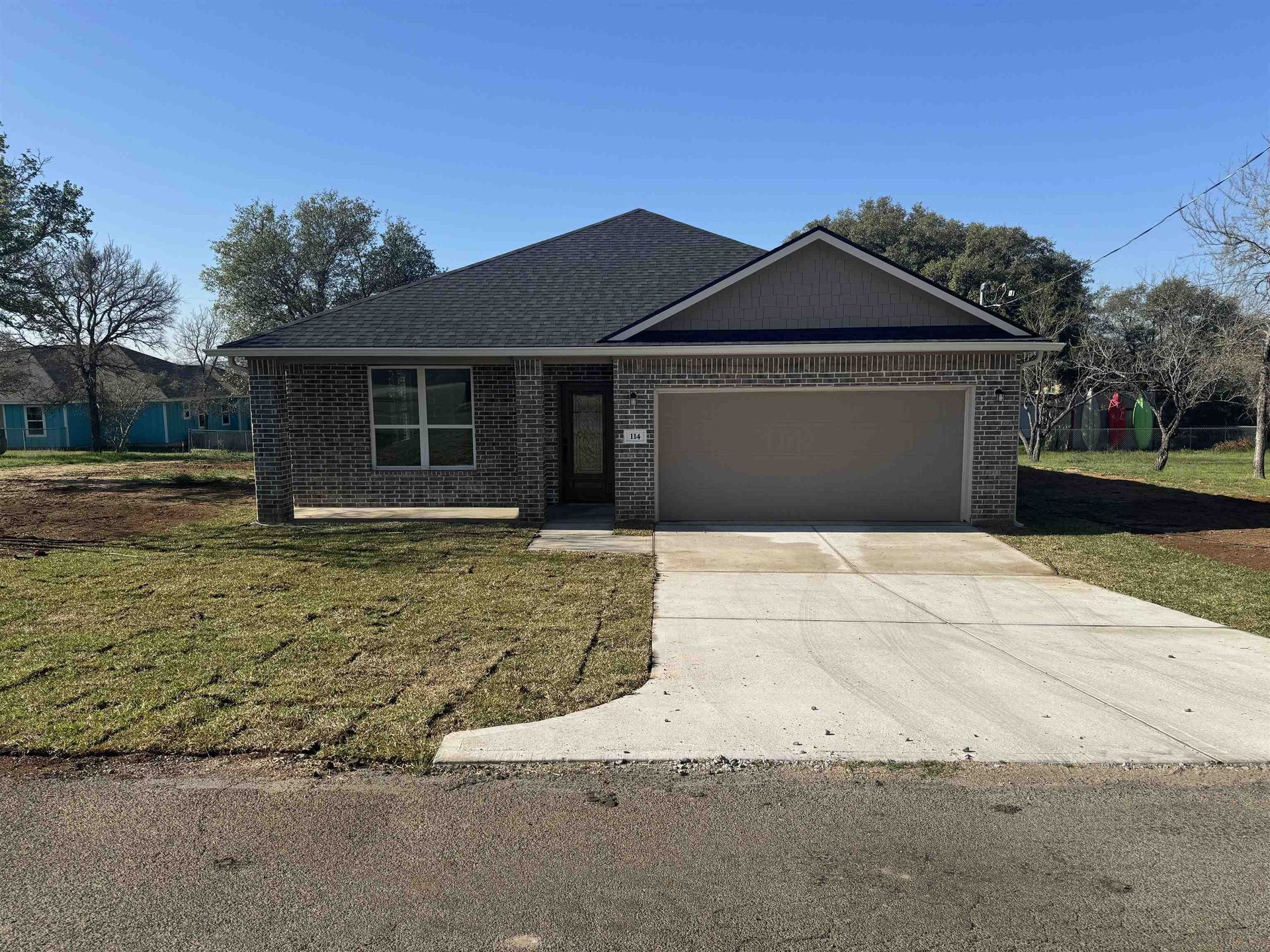 A house with a garage and a driveway in front of it.