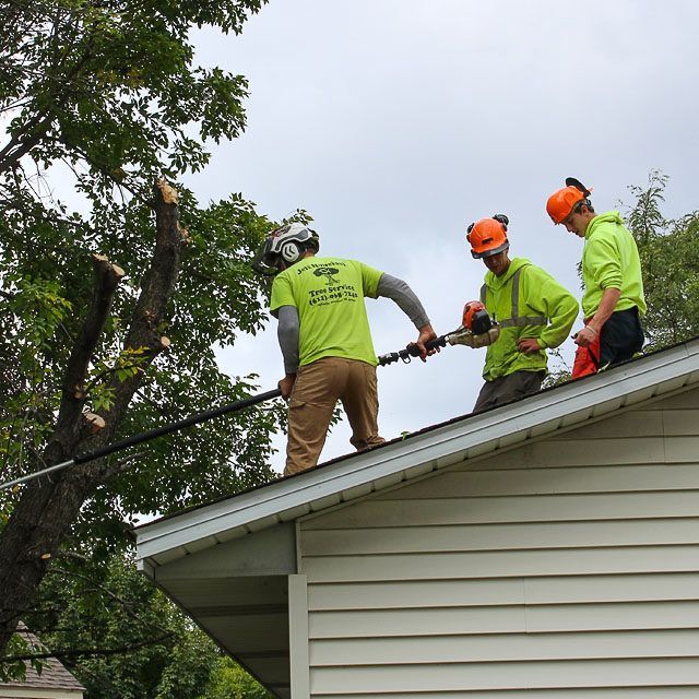 Three men are working on the roof of a house