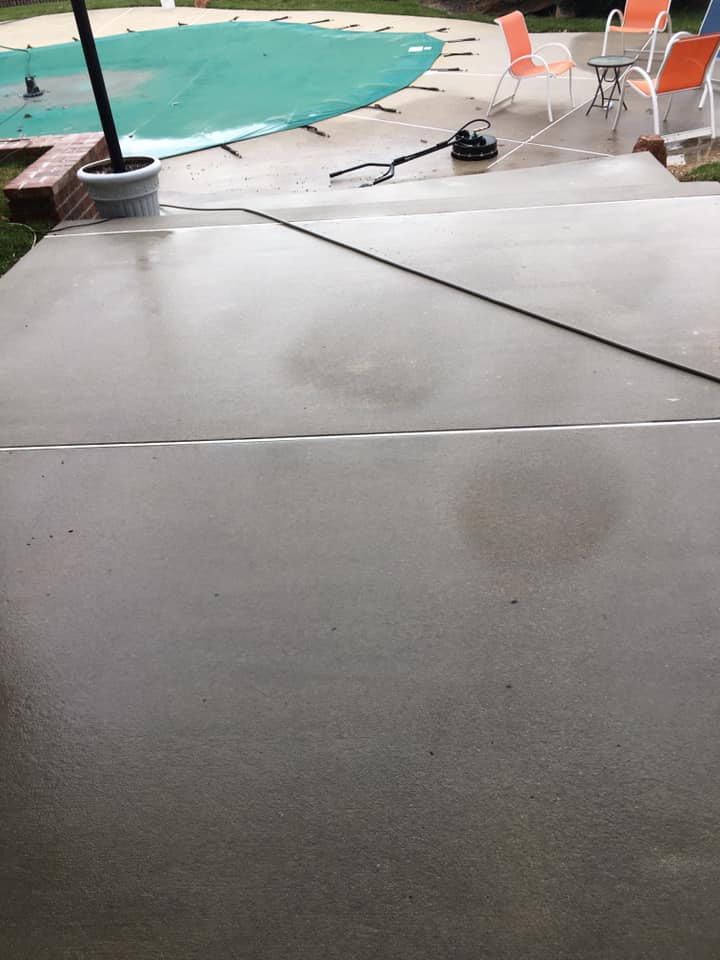 A patio with a table and chairs next to a pool.