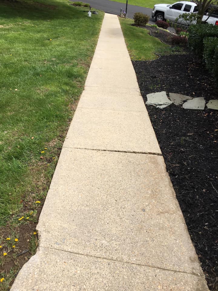 A sidewalk with a truck parked on the side of it.