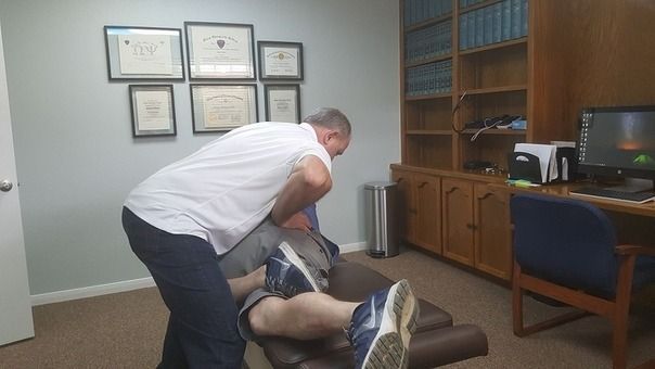 Man assisting an injured person on the floor in an office room