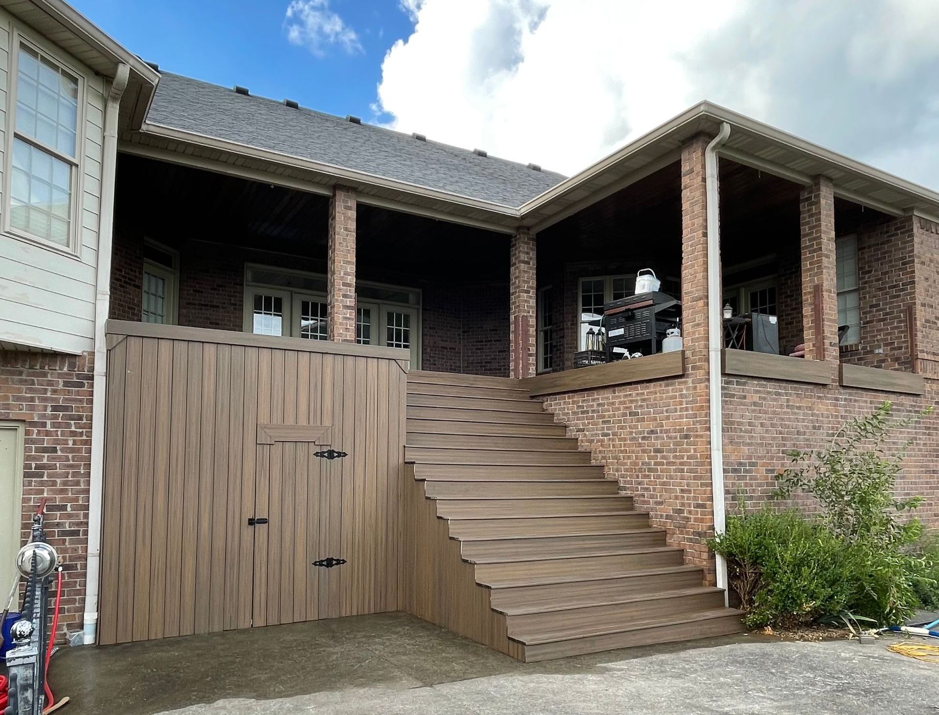 A brick house with a wooden deck and stairs