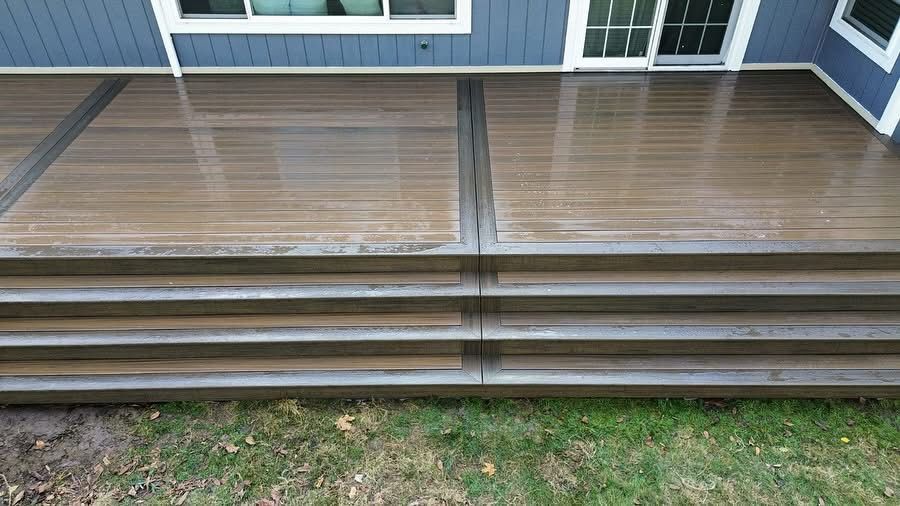 A wooden deck with stairs leading up to it in front of a house.