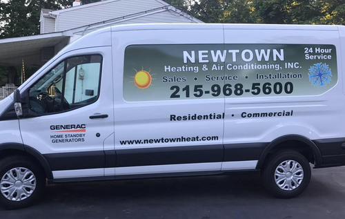 White Newtown Heating & Air Conditioning van. Green and blue logo with phone number.