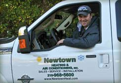 Man in a work truck, Newtown Heating & Air Conditioning logo visible. Man in a work truck, Newtown Heating & Air Conditioning logo visible.