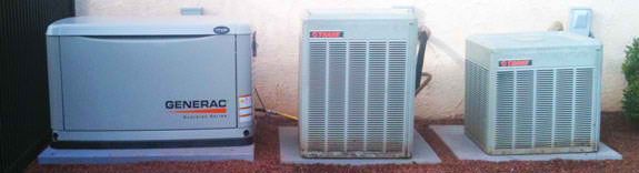 A standby generator and two air conditioning units are on concrete pads outdoors.