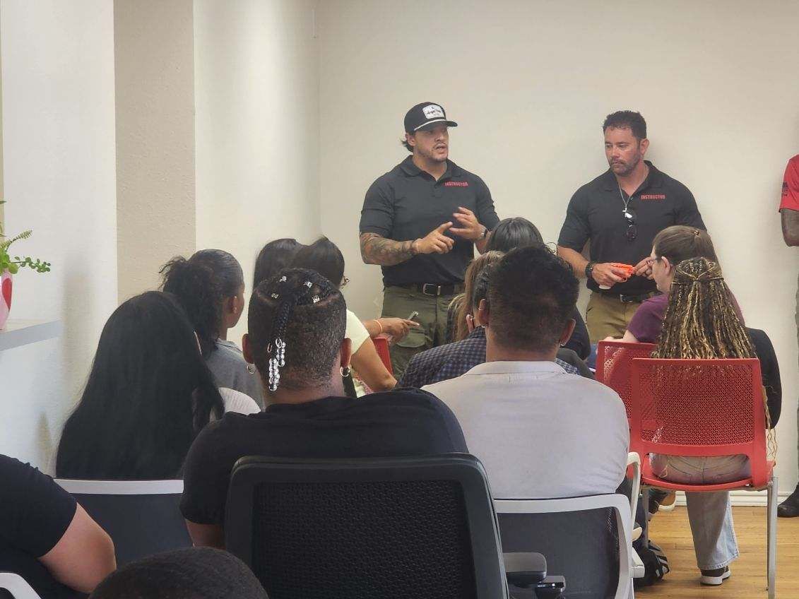 Two men giving a presentation to a group of people seated in chairs.