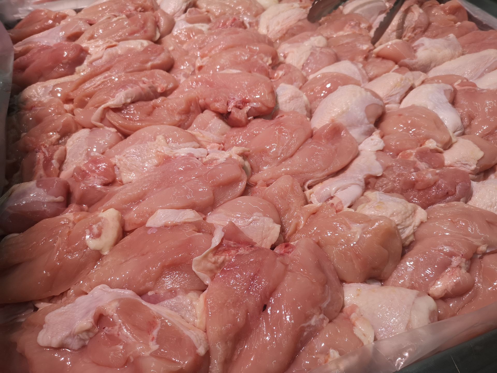 A pile of raw chicken is sitting on a table.