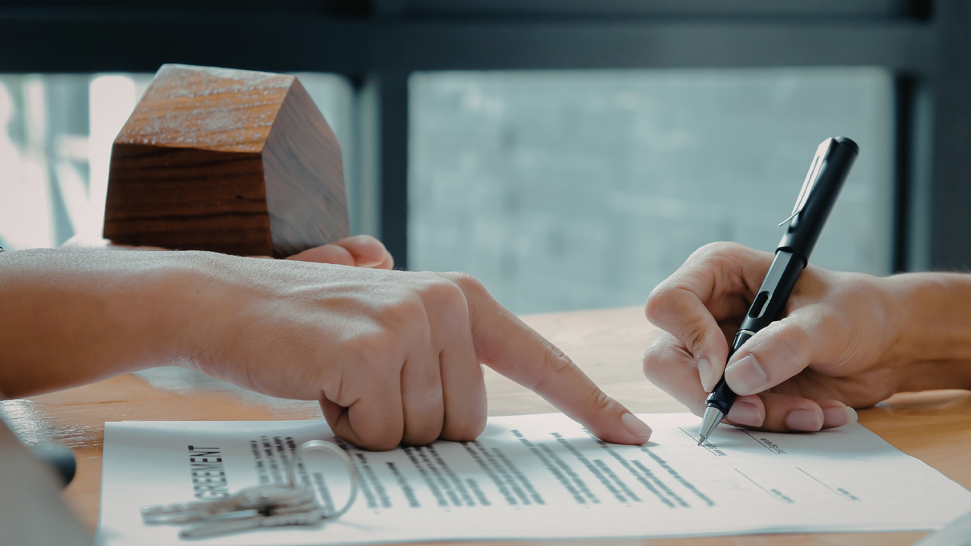 Person using calculator and laptop, working on financial documents.