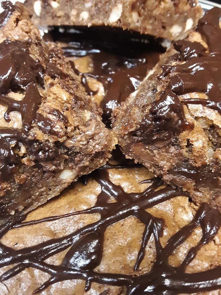 Close-up of chocolate brownies, cut into squares, drizzled with dark chocolate.