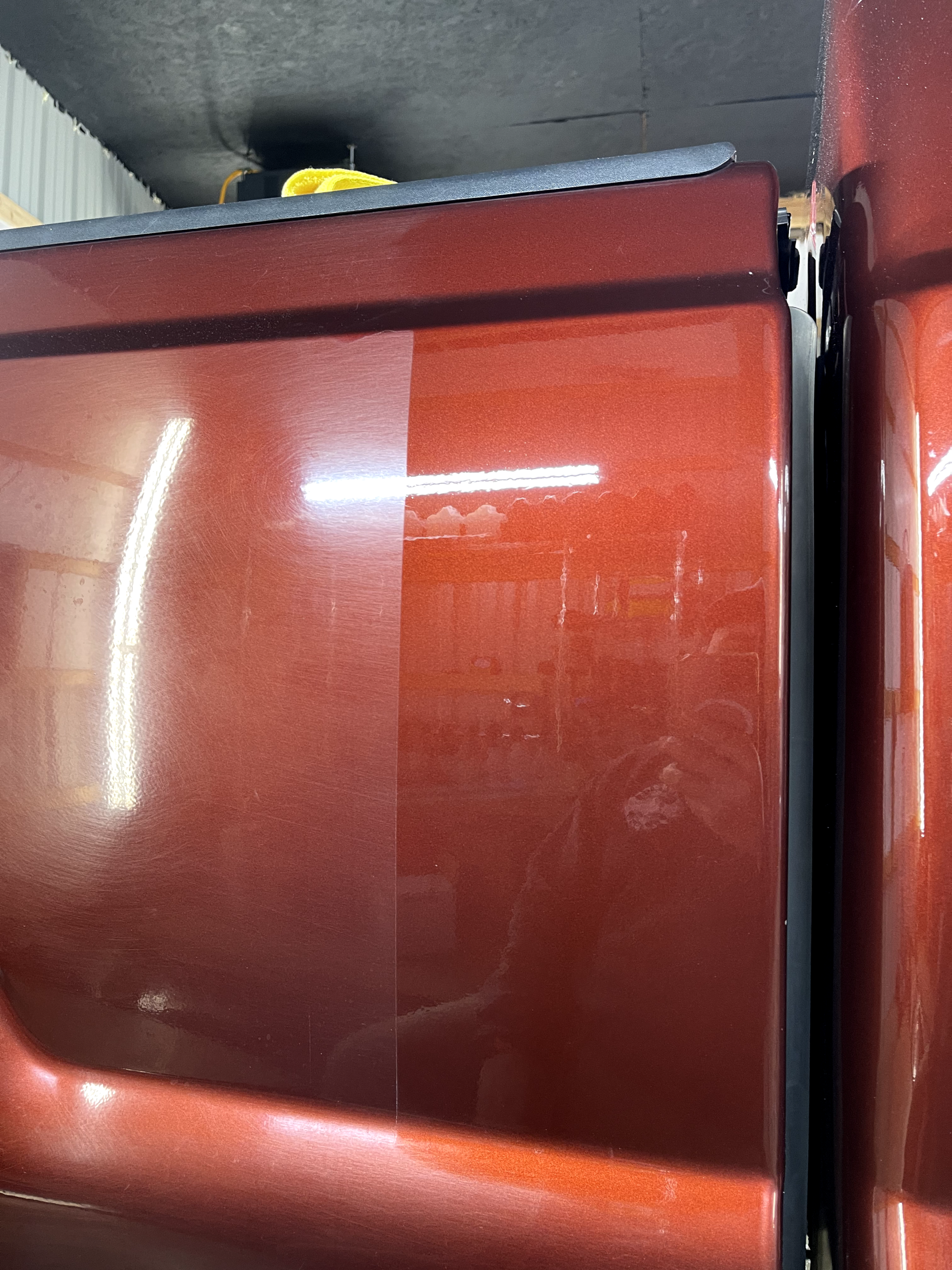 a close up of a red car door in a garage .