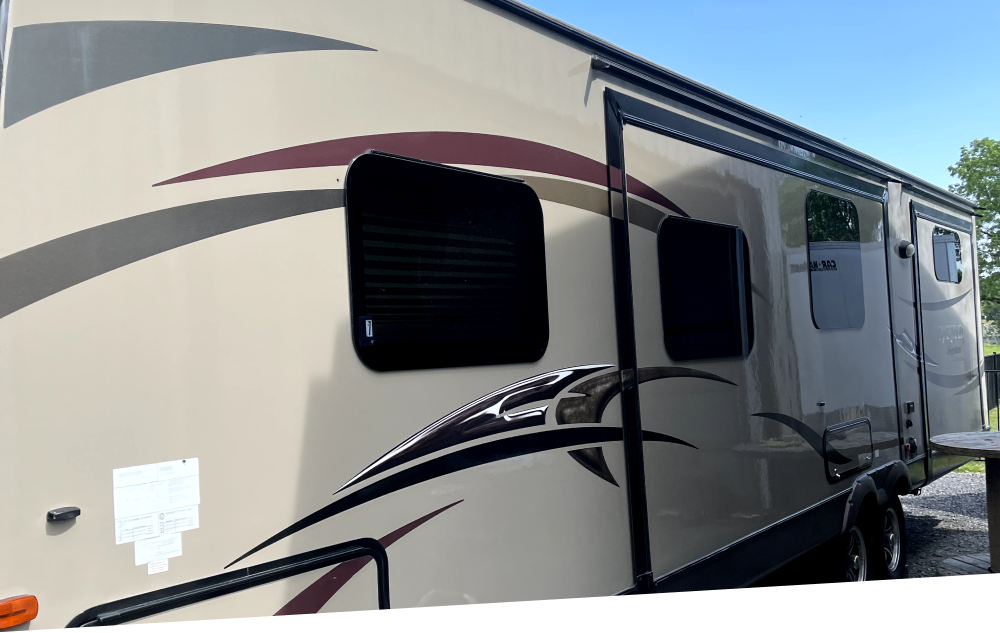 a rv is parked in a parking lot on a sunny day .